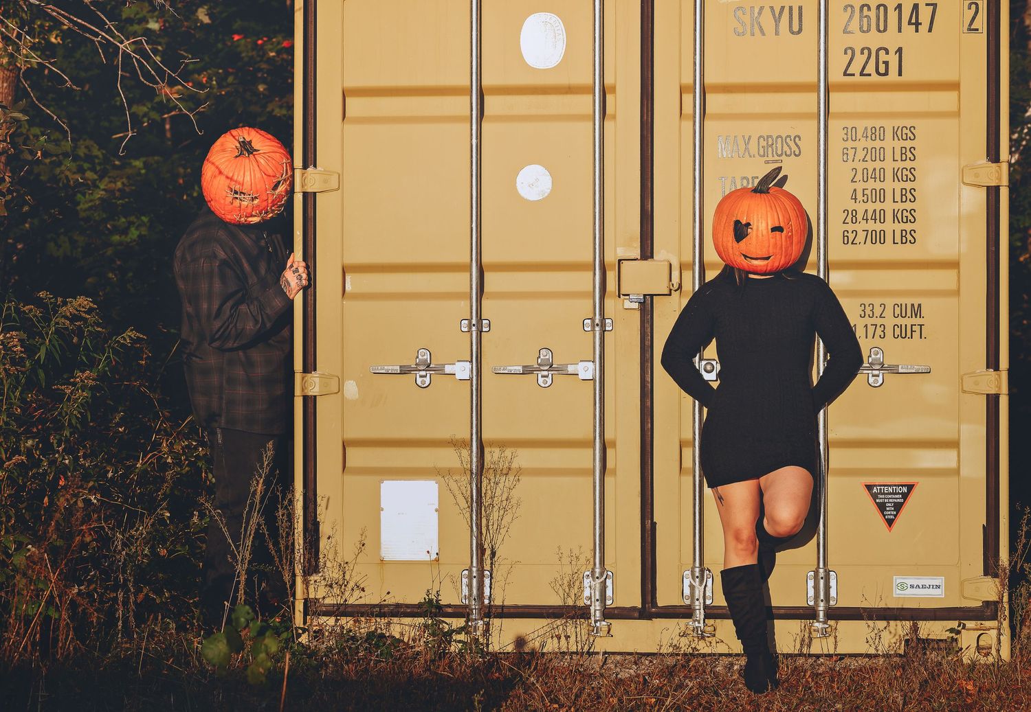Pumpkin head man peaking over at a pumpkin headed woman