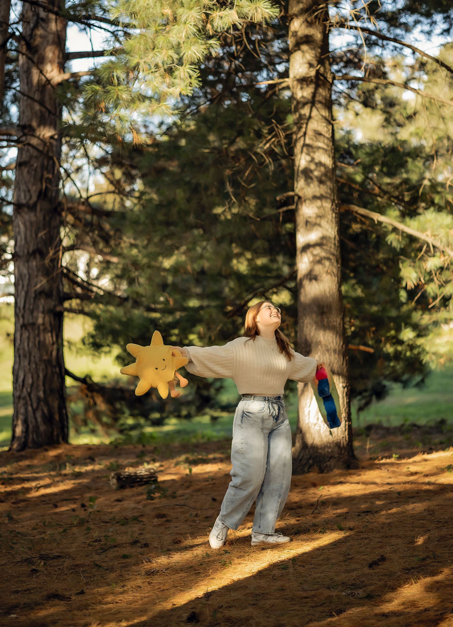 Girl holding a star and rainbow in the woods