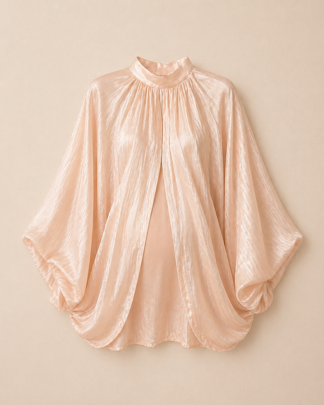 Elegant beige satin cape blouse with gathered mock neck, batwing sleeves, and open front drape silhouette.