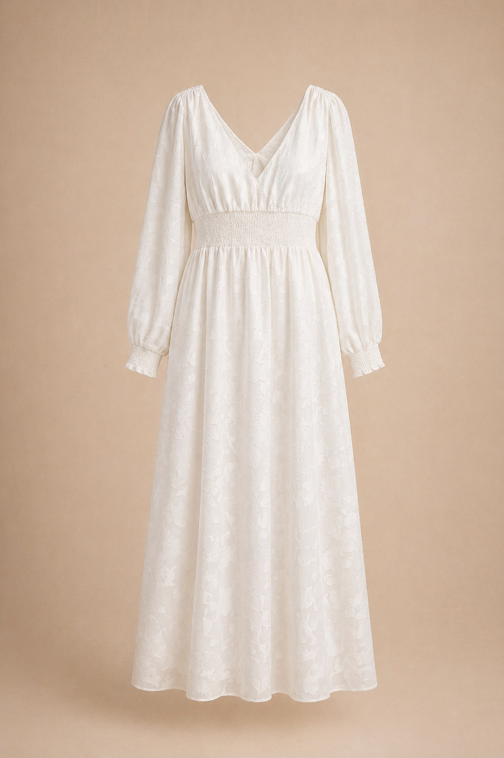 White long-sleeve maxi dress with V-neckline, smocked waist, and flowy A-line skirt in delicate floral fabric.