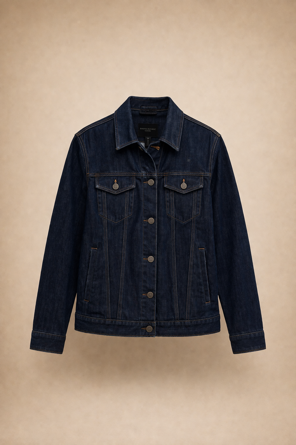 Dark wash denim jacket with button front, chest pockets, and classic trucker styling.