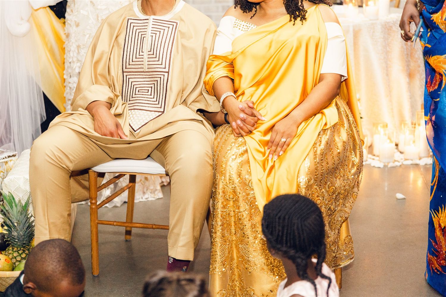 Wedding party members in gold dresses and formal attire celebrate during an elegant reception.