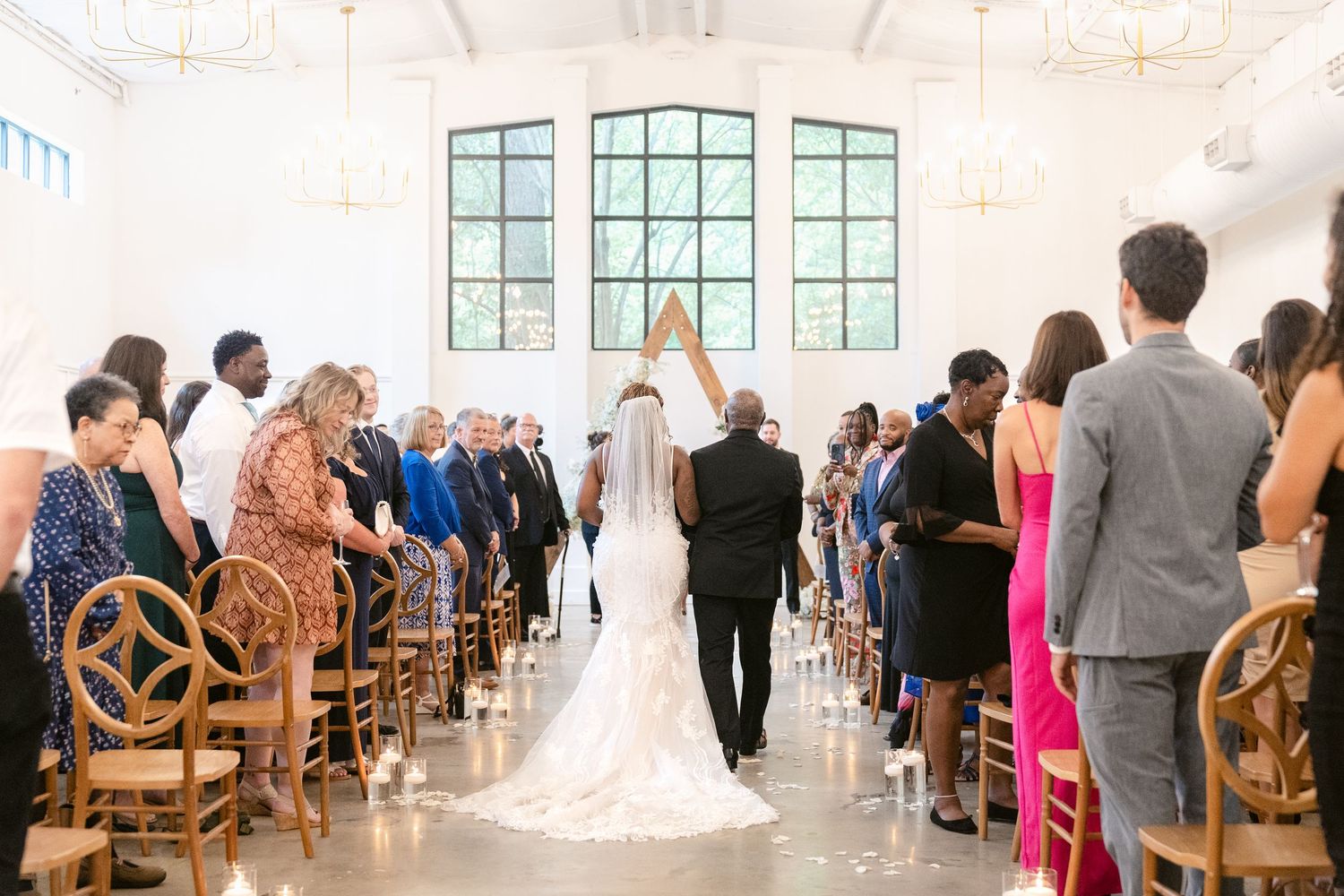 Elegant white wedding chapel interior with wooden chairs and natural lighting.