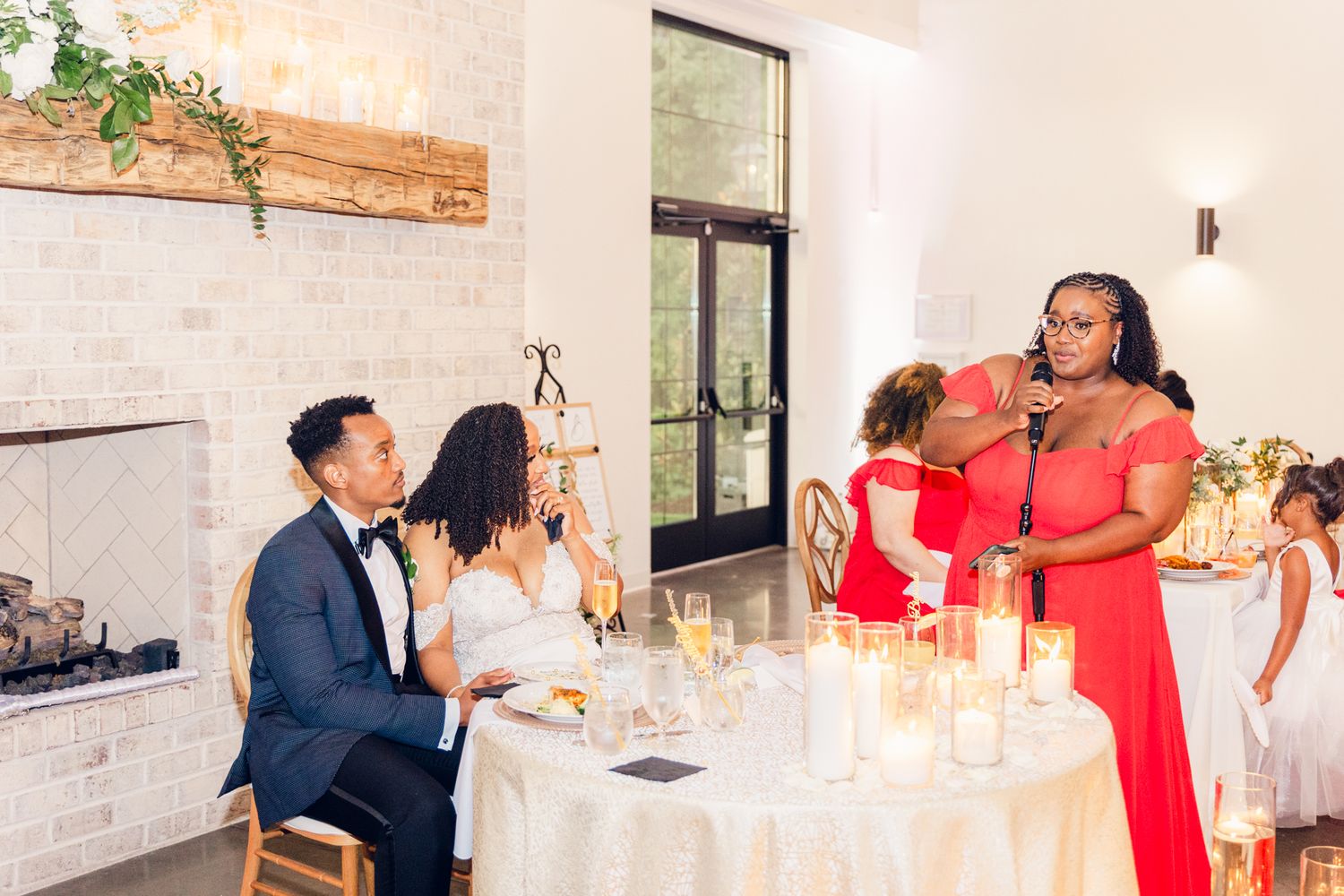 Wedding guests dance and celebrate together at an elegant indoor reception venue with white decor.