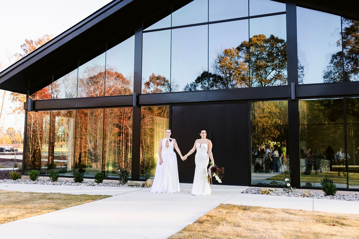 A modern glass-walled wedding venue with black beams showcases multiple views of a scenic outdoor landscape.