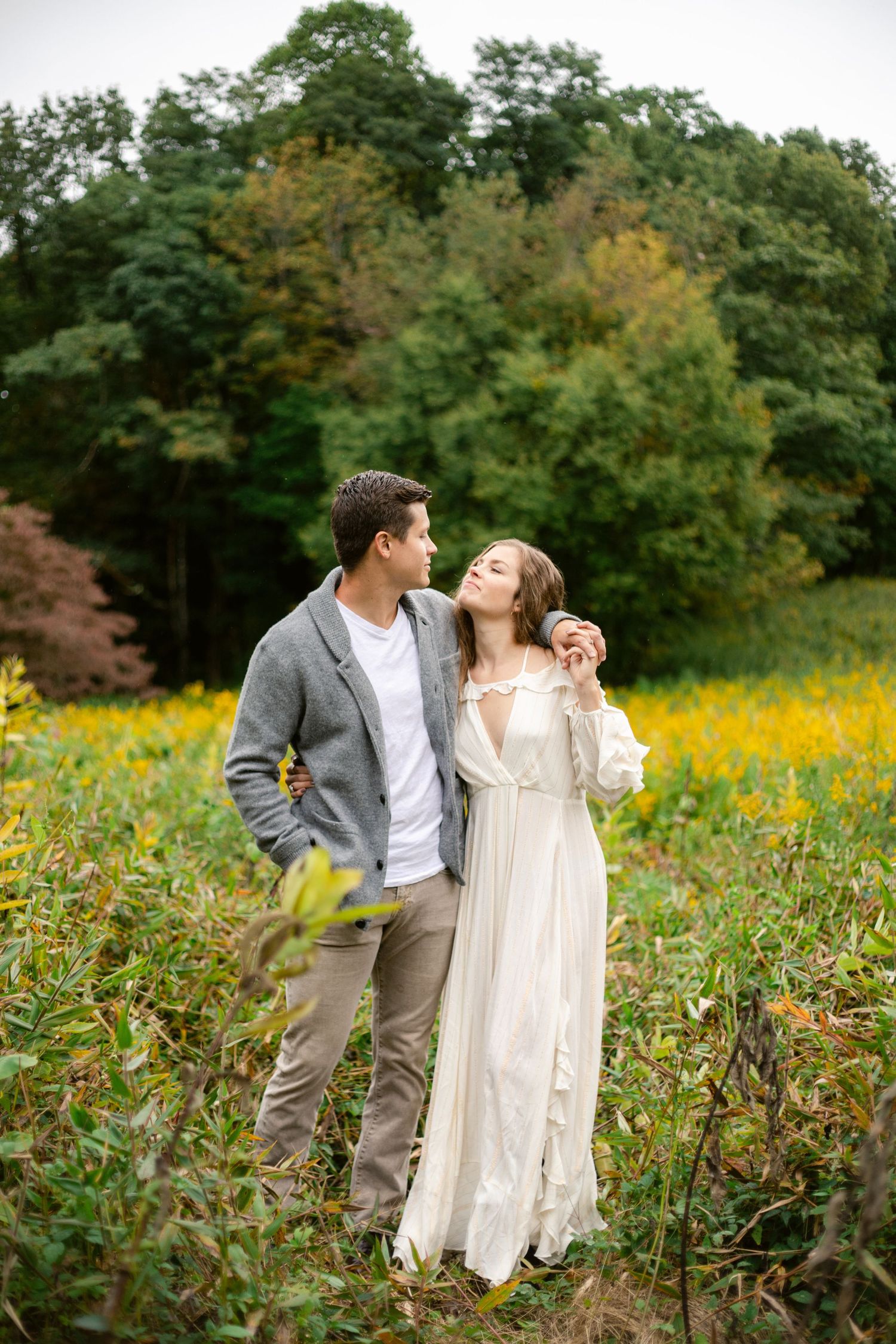 A romantic couple sharing a tender moment in a field of autumn wildflowers.