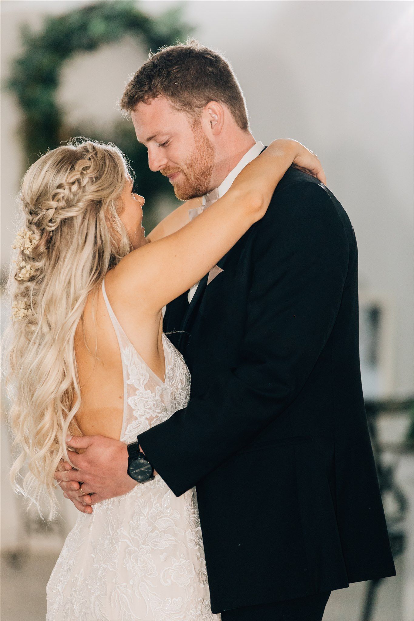 Romantic close-up of couple embracing during wedding reception.