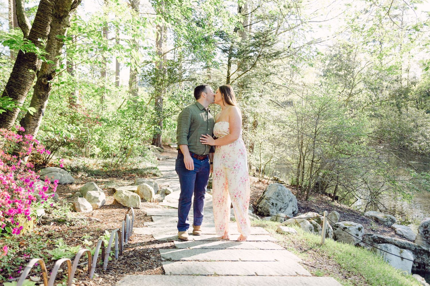 Couple walks along wooded path during outdoor wedding ceremony in natural forest setting.
