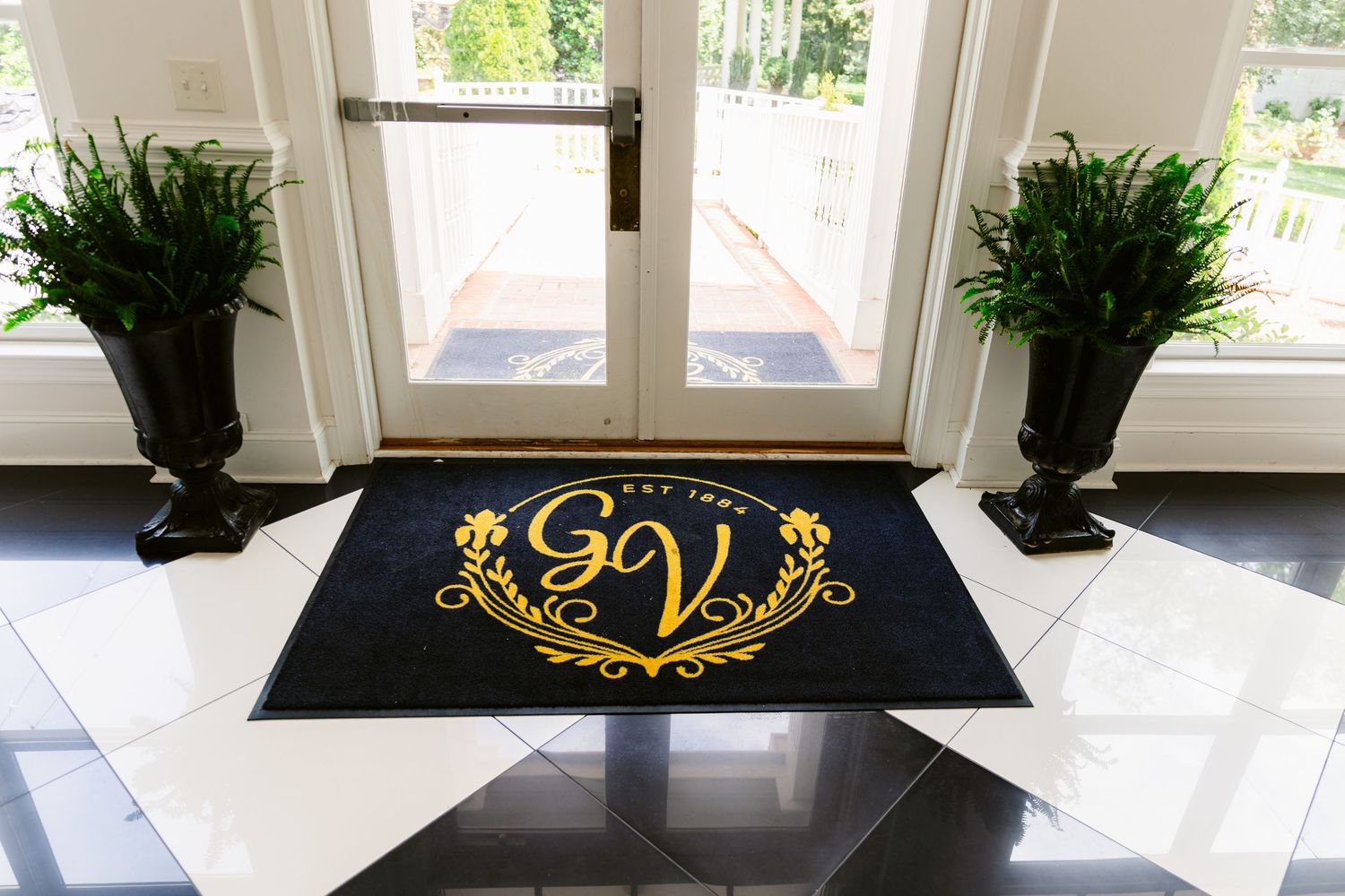 Custom monogram signage and greenery displayed on window sills in an event space.