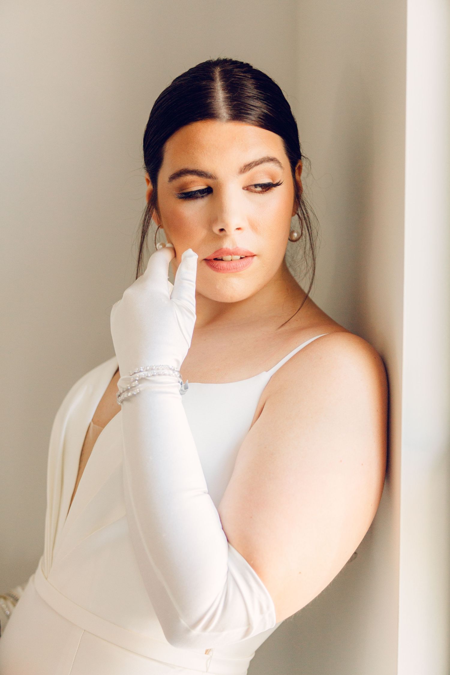Elegant bridal portrait in white against neutral background.
