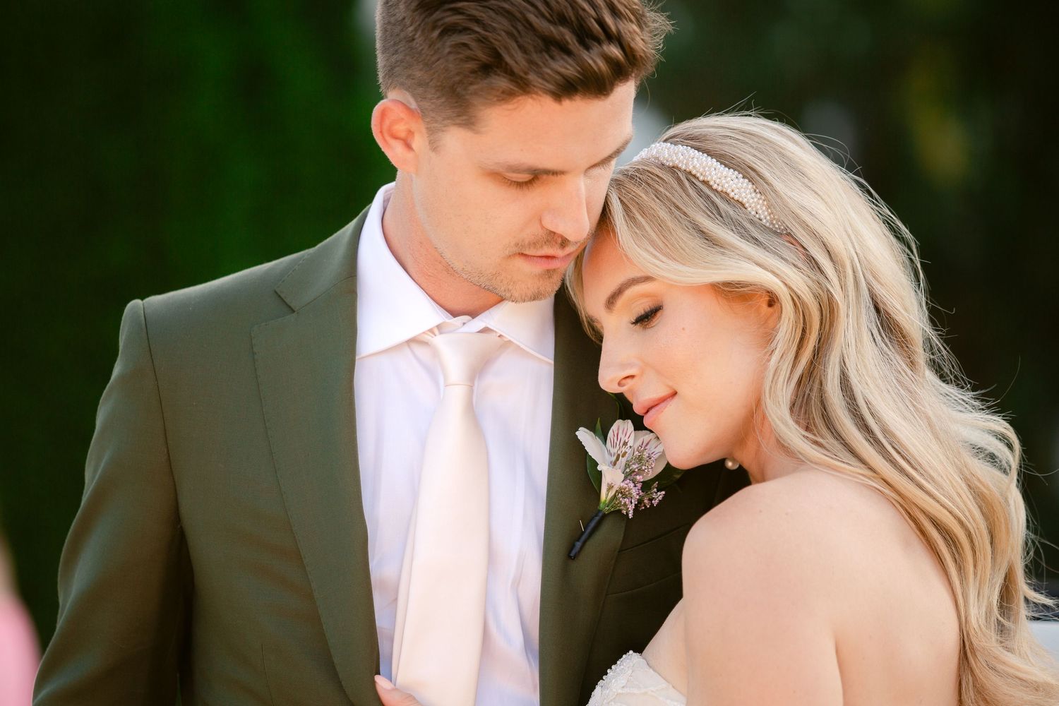 A romantic couple shares an intimate moment in an outdoor garden setting with soft natural lighting.