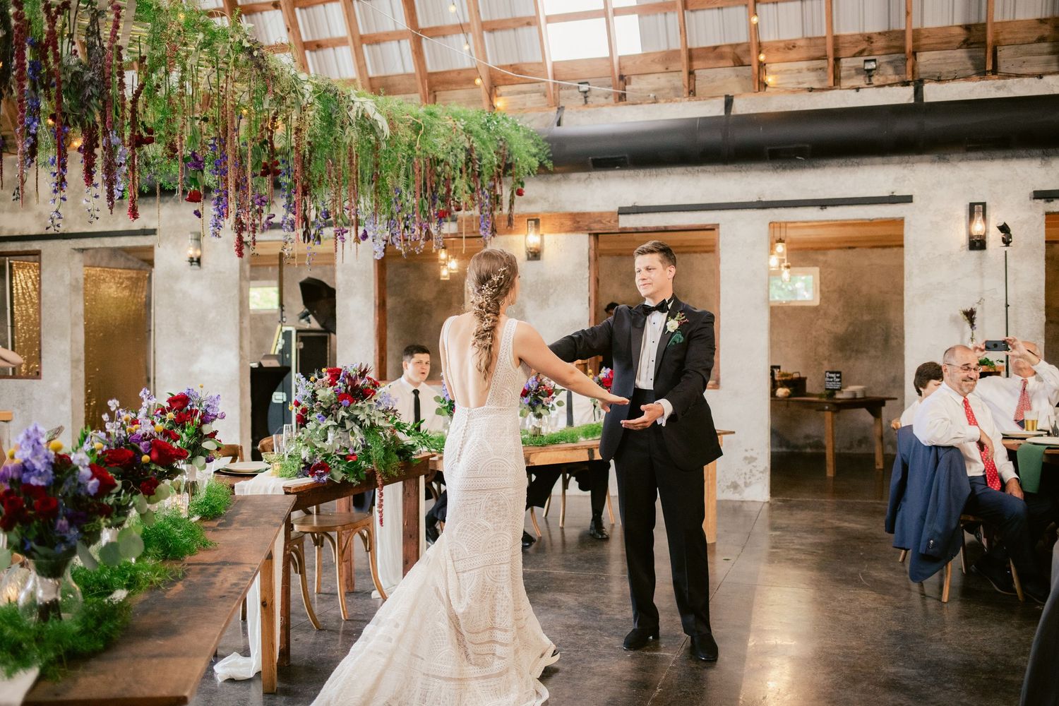 Elegant wedding reception venue with rustic wooden beams and romantic lighting creates an intimate atmosphere for celebration.