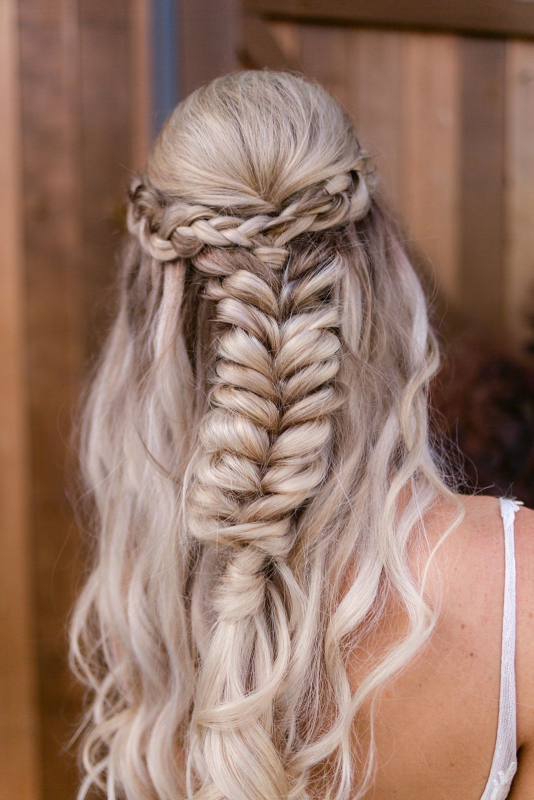 Intricate bridal hairstyle featuring platinum blonde fishtail braid with delicate crown braiding details.