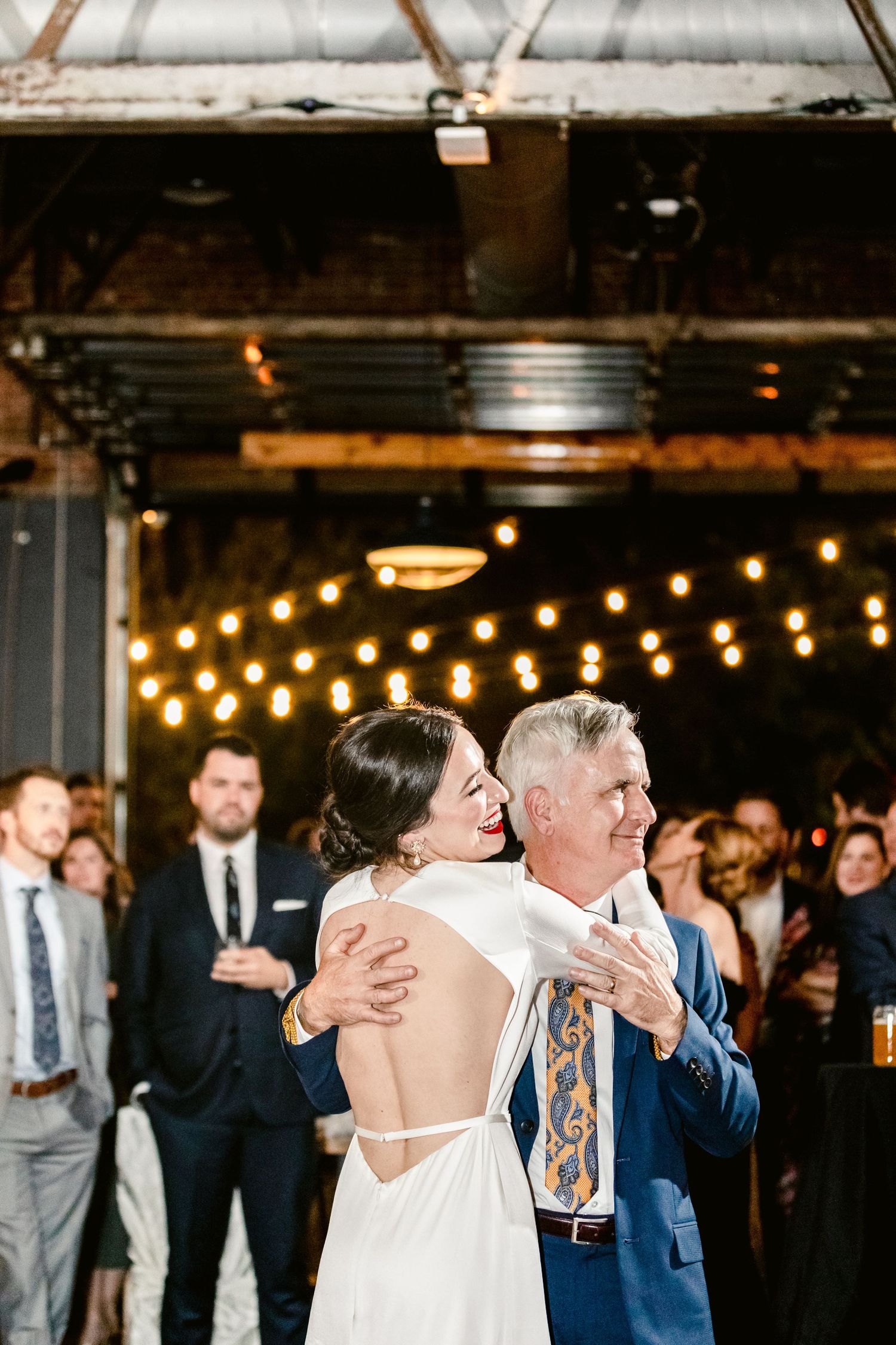 Wedding celebration in a rustic indoor venue with string lights creating a warm ambiance.