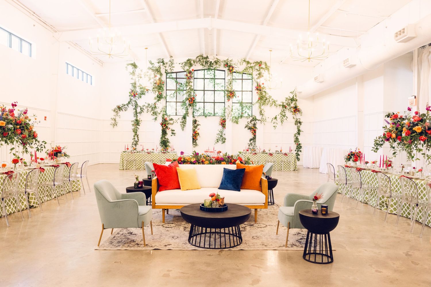 Contemporary wedding reception venue with floral decor and modern lounge furniture.