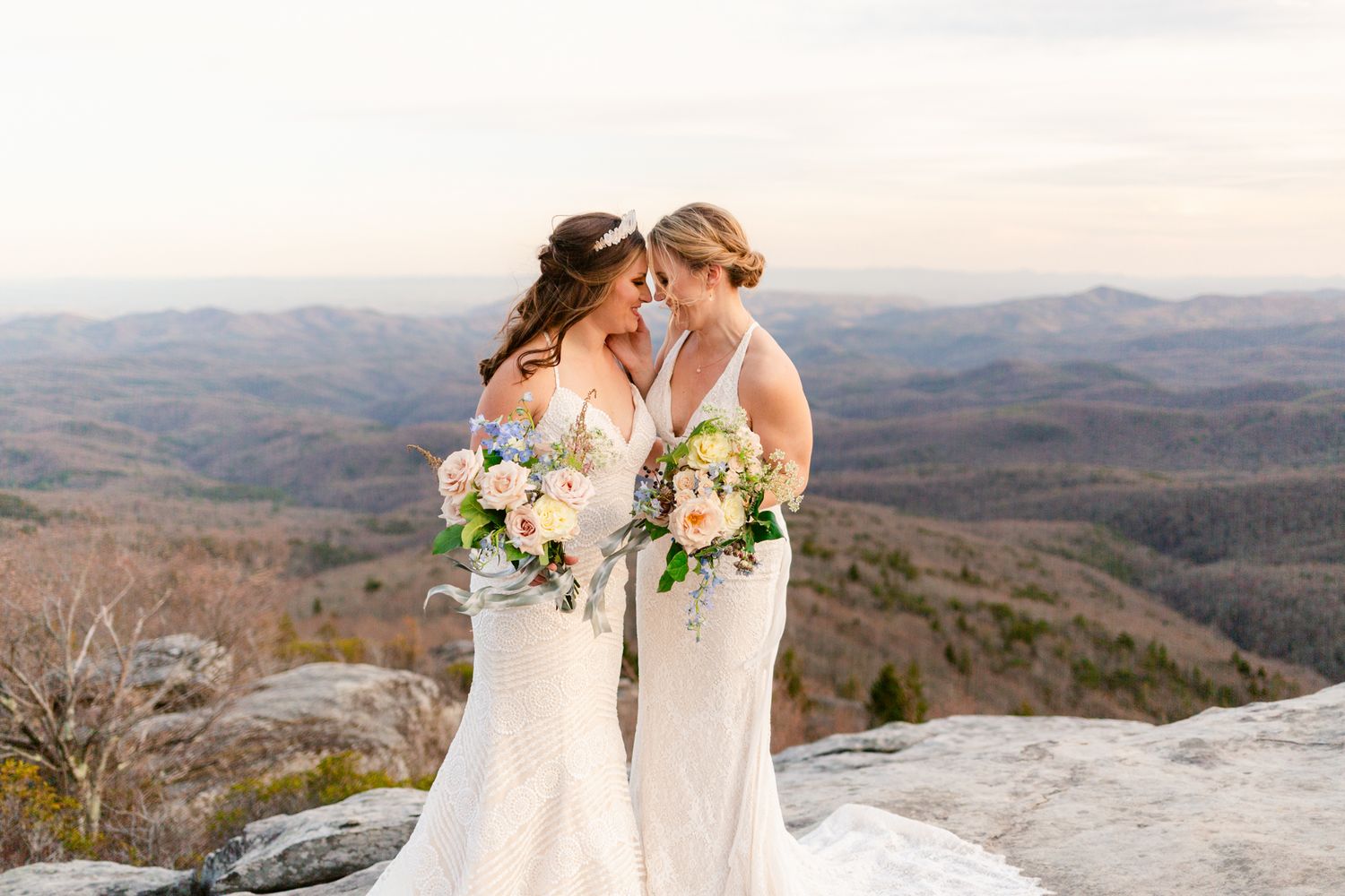 Bride and groom share intimate moments against a scenic mountain backdrop during their outdoor wedding photoshoot.