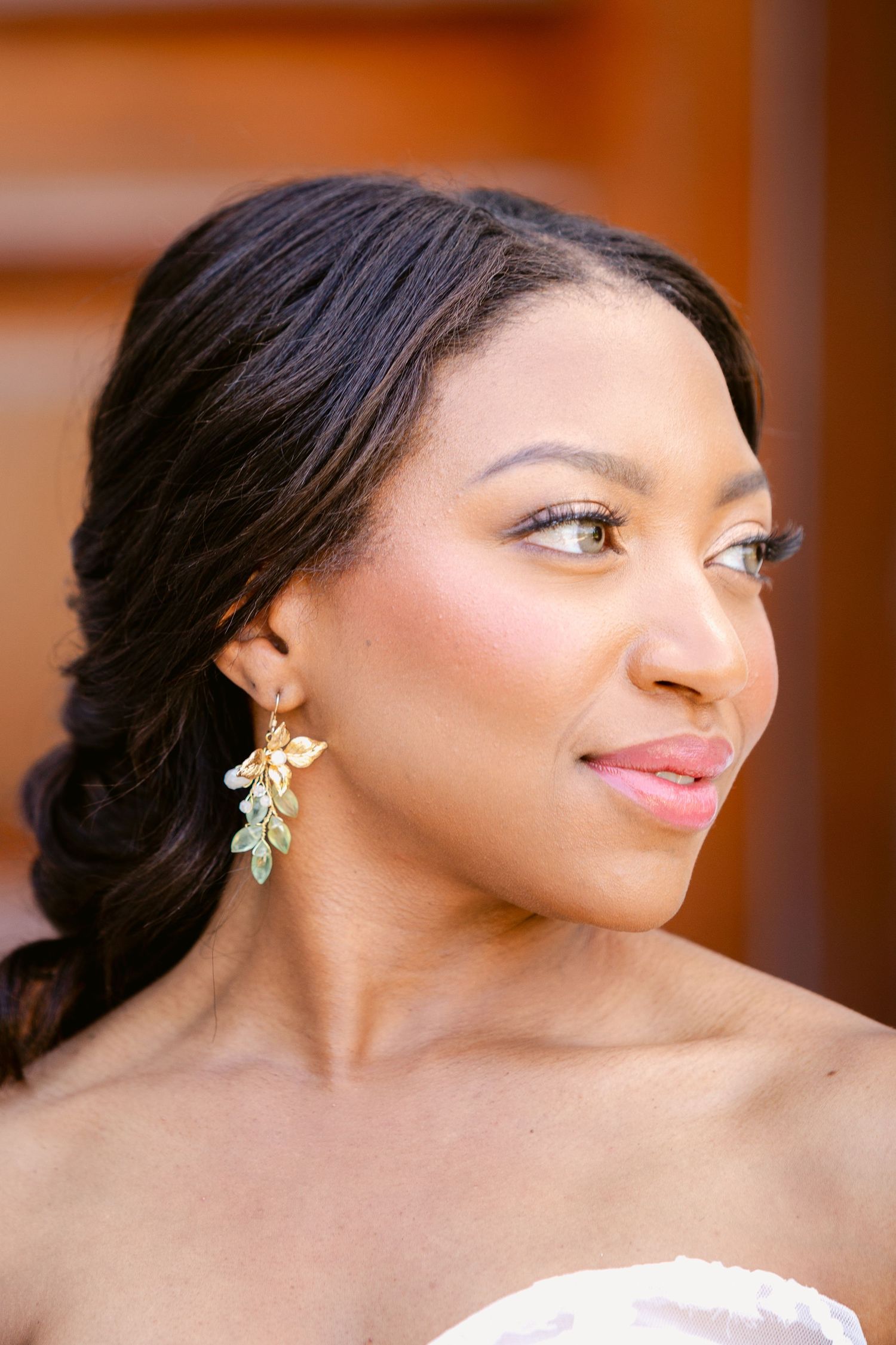 A woman in elegant makeup and sparkly earrings poses with a glowing smile in a series of glamour shots.
