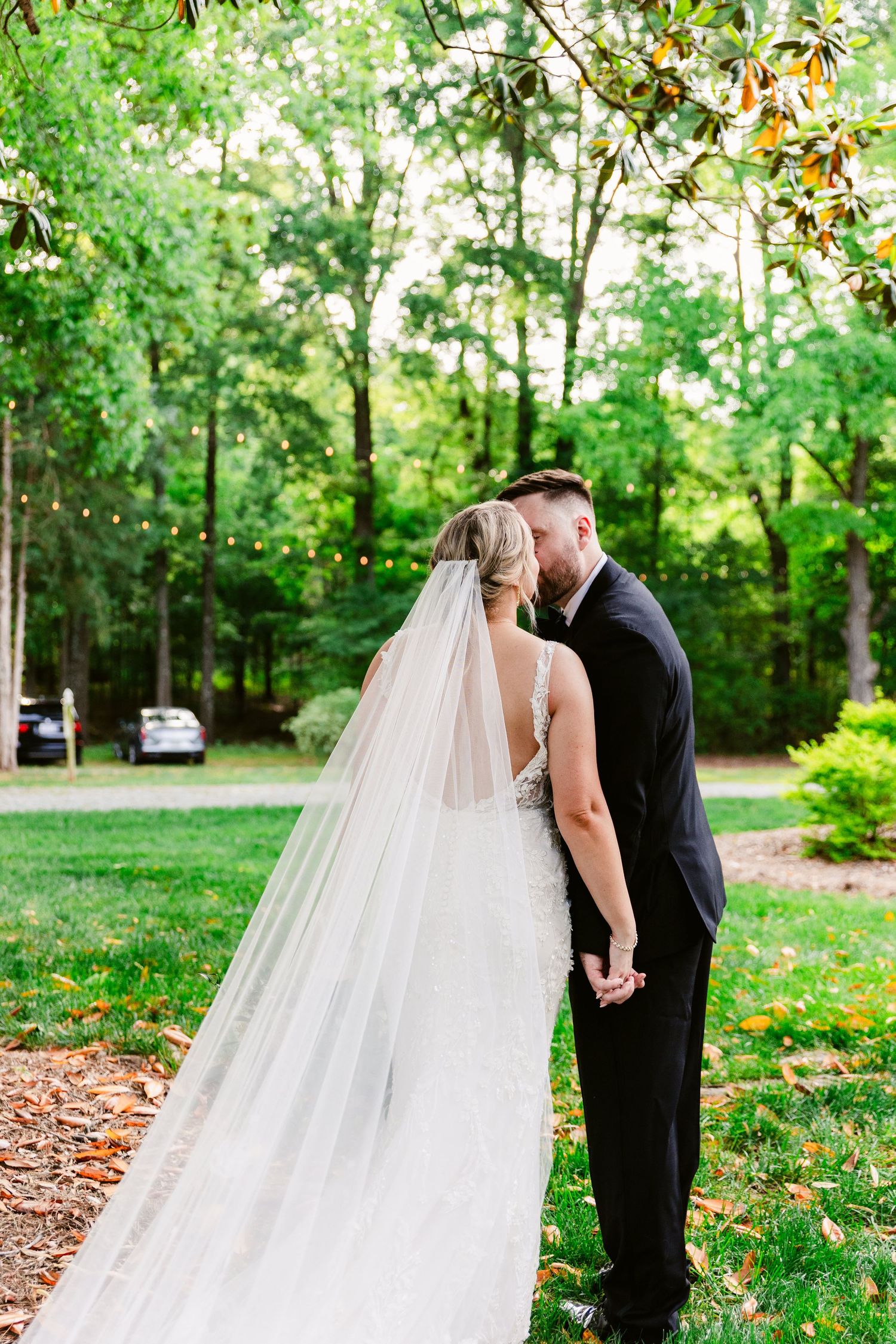 Romantic wedding couple shares tender moments in a lush green garden setting during their outdoor photo session.