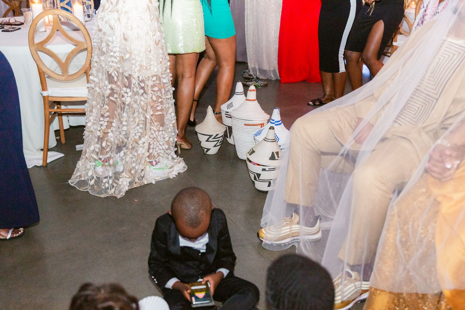 Wedding guests dancing and celebrating on a dance floor at an indoor reception venue.