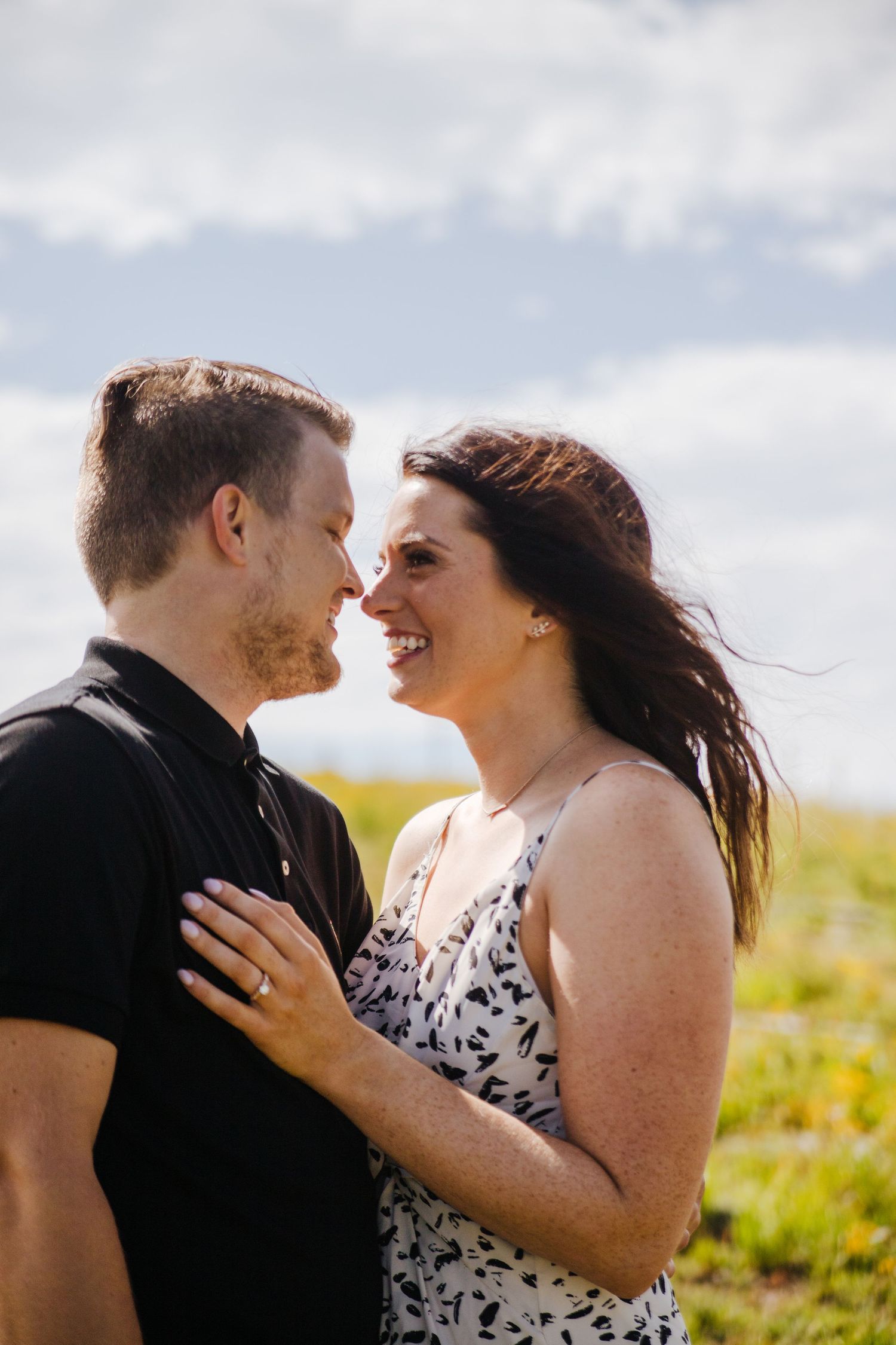 Romantic close-up of couple sharing a tender moment in a mountain meadow setting.