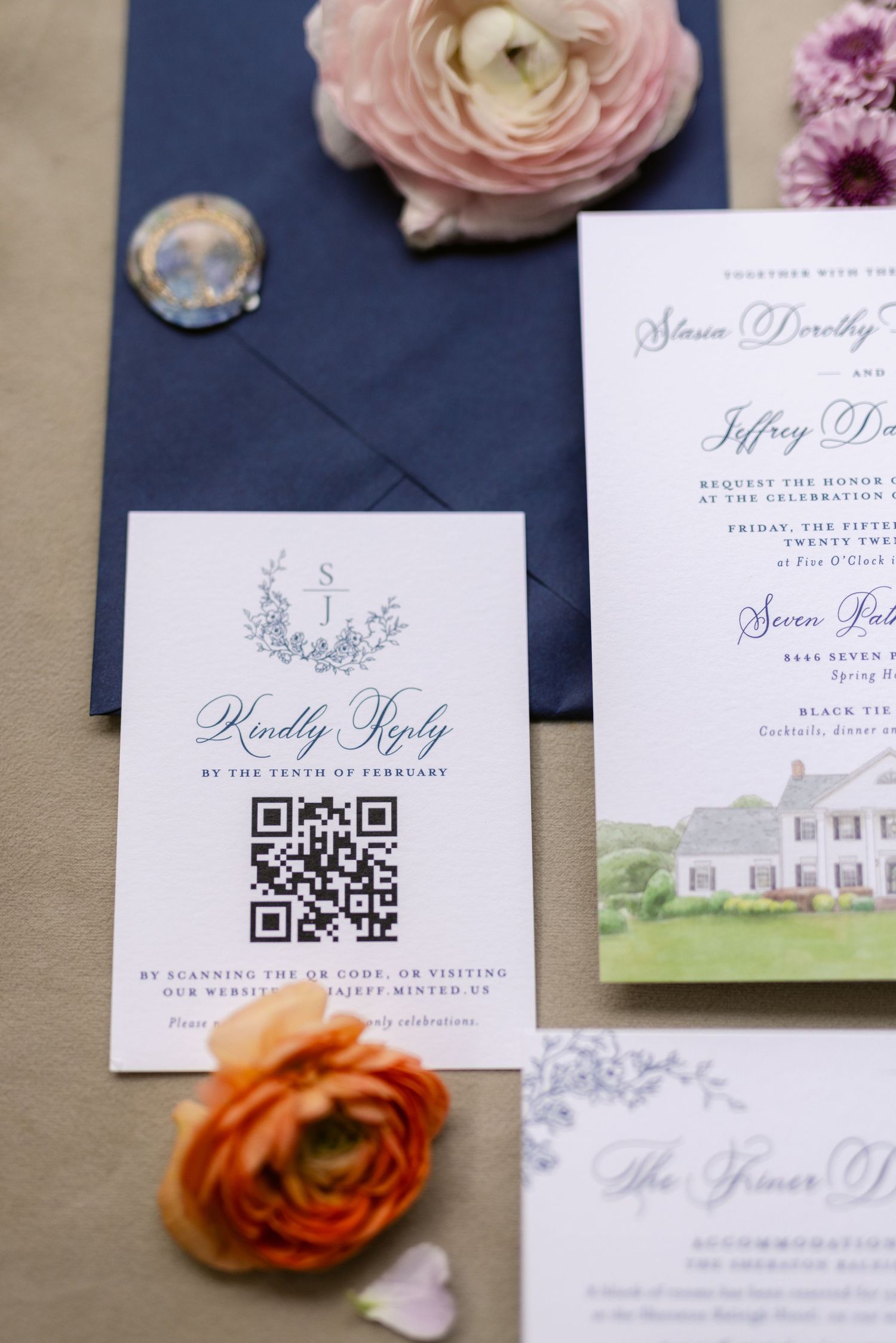 Wedding invitation suite with QR code, navy blue envelope, pink and orange ranunculus flowers, and watercolor venue art.
