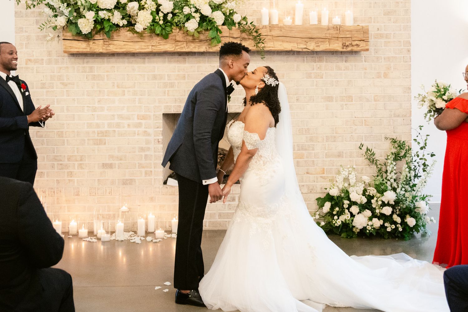 Romantic wedding ceremony with candlelight and floral arrangements against a brick wall backdrop.