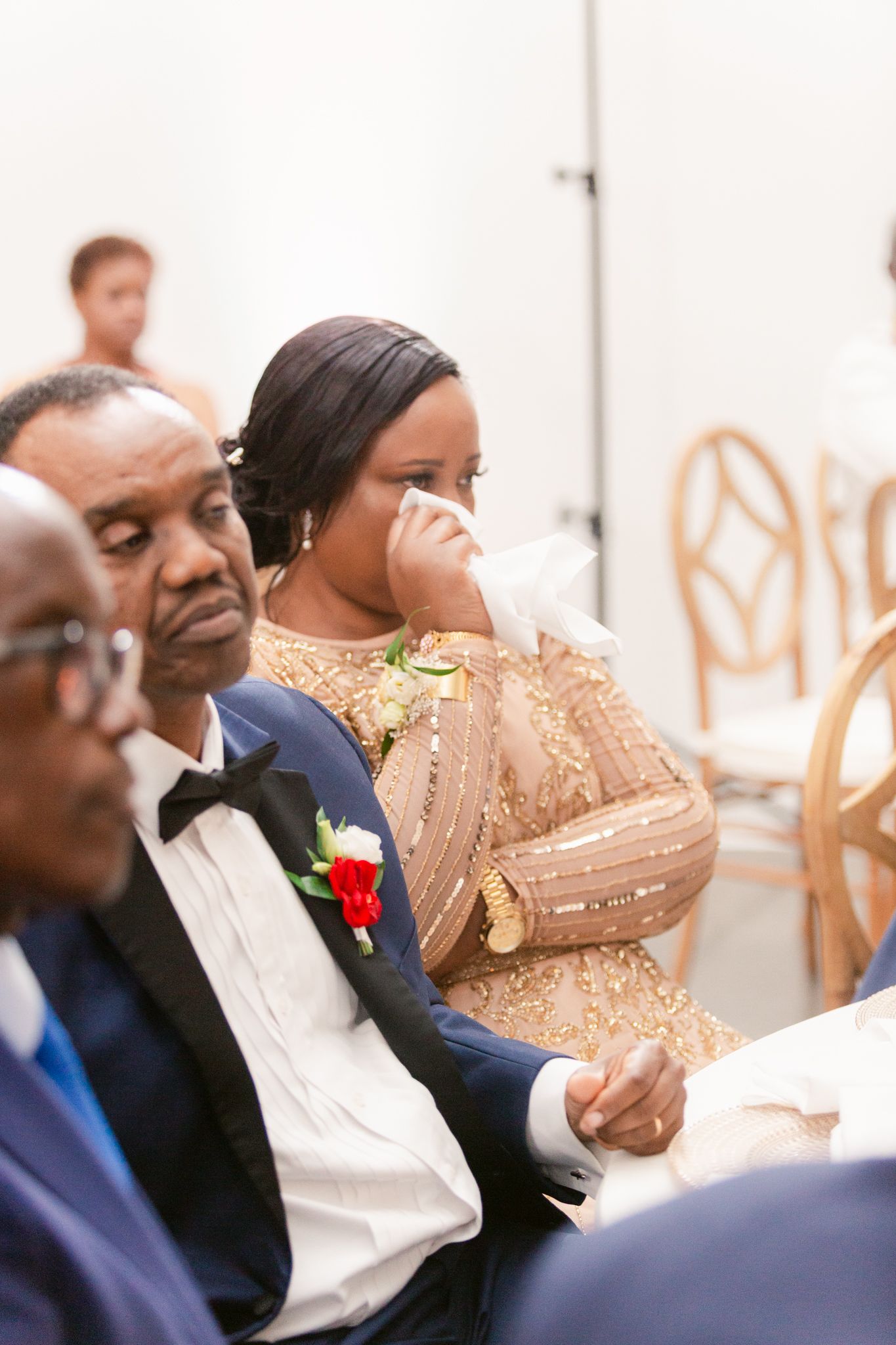 Wedding guests sharing joyful laughter during an emotional reception moment.