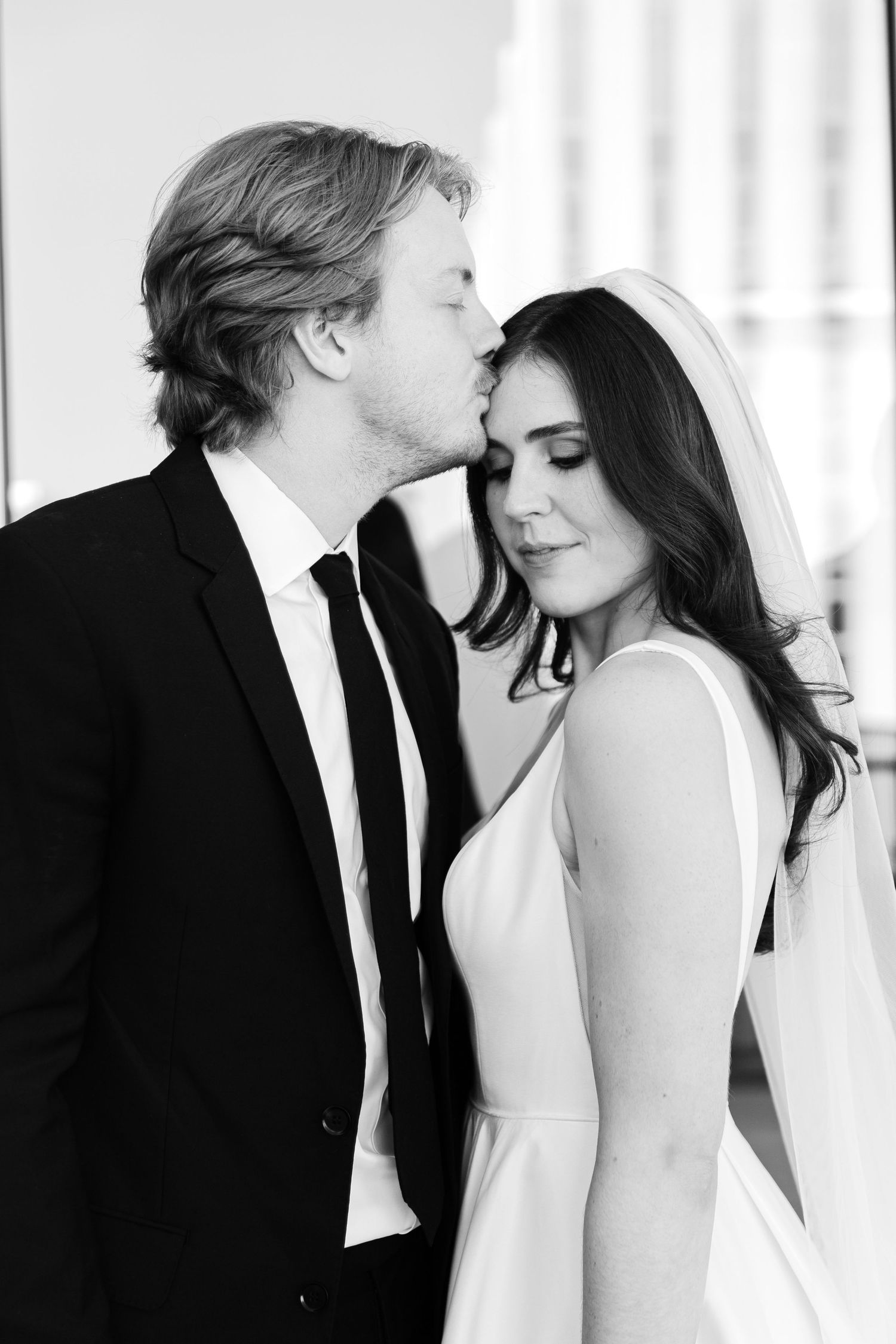 Romantic black and white portrait of newlyweds sharing an intimate moment.