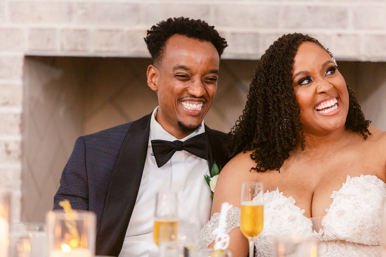 Wedding guests enjoying a celebratory moment with drinks and laughter at an elegant indoor reception.