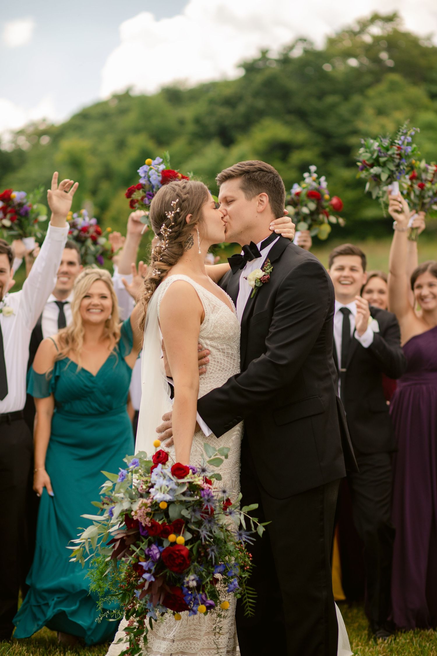Wedding celebration moment with guest cheering in background during outdoor ceremony.