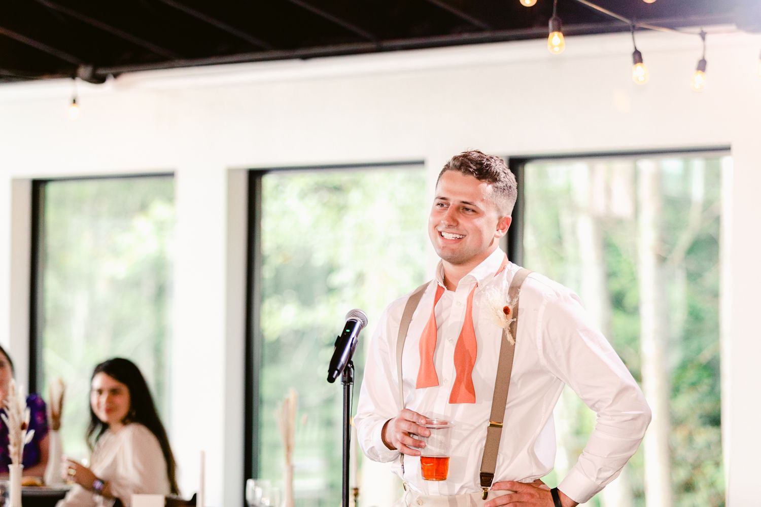 Wedding guests dance and celebrate together during a lively reception in a bright indoor space.