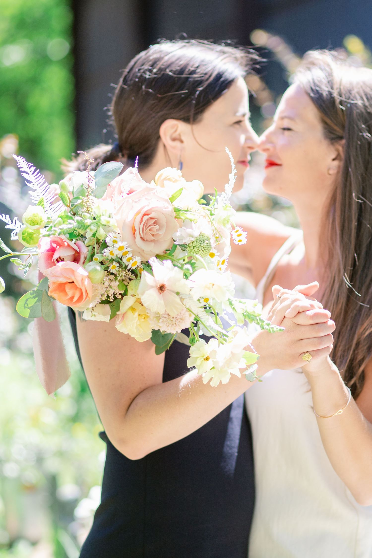 Two people share an intimate moment with a beautiful spring bouquet.