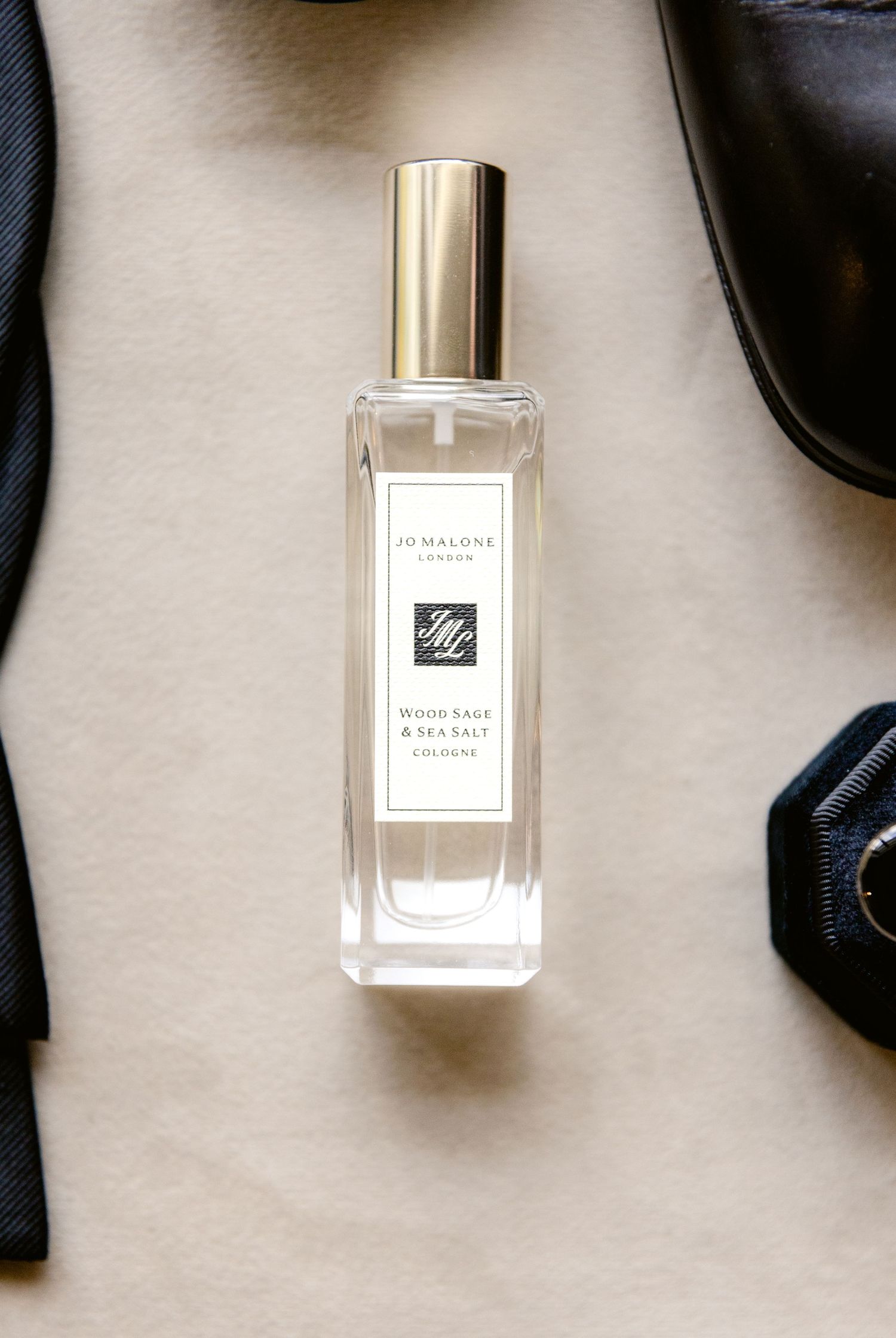 Luxury perfume bottles and sunglasses arranged on a white surface in minimalist style.