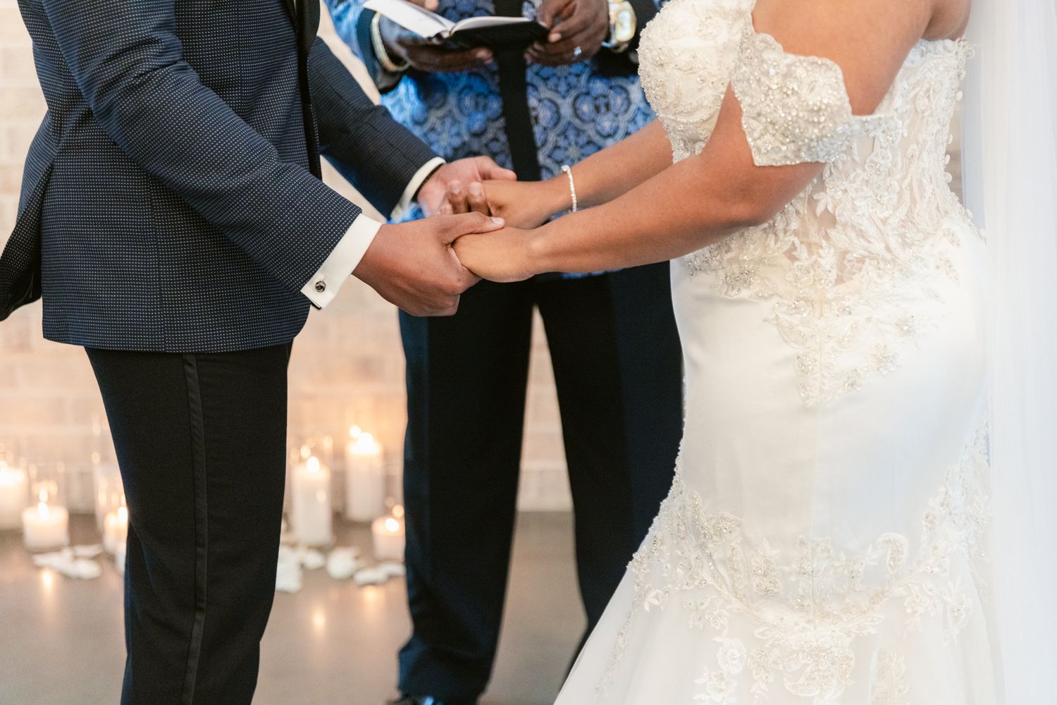 A close-up sequence of hands exchanging wedding rings during an intimate ceremony.