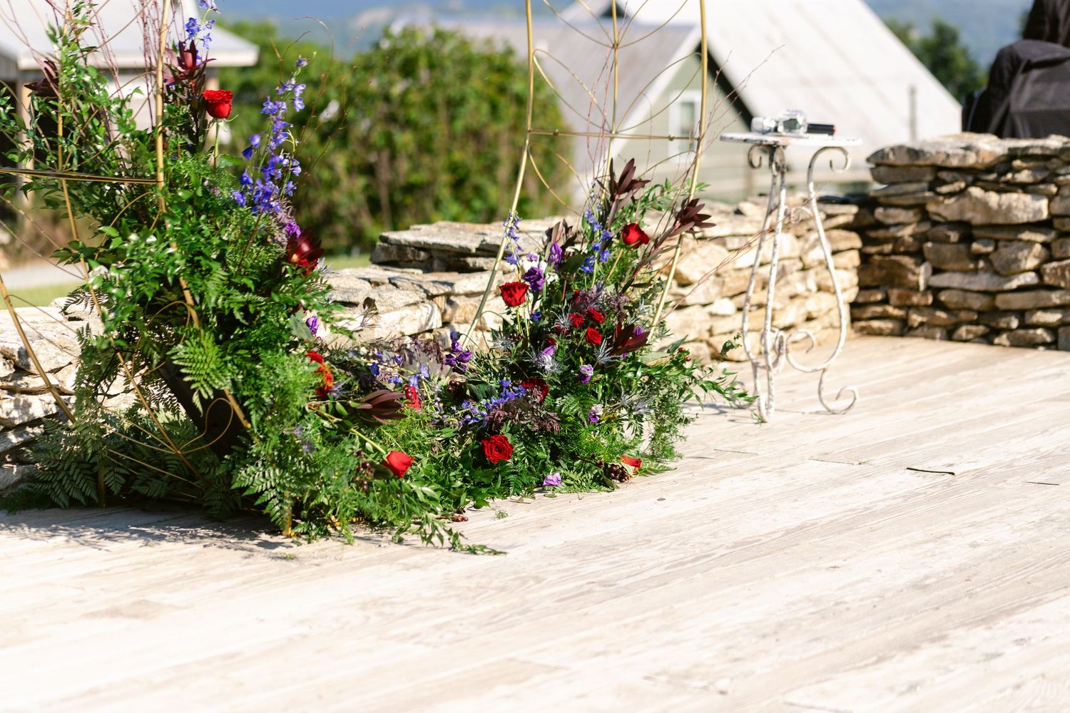 Colorful wildflower arrangement decorating a stone wall pathway.
