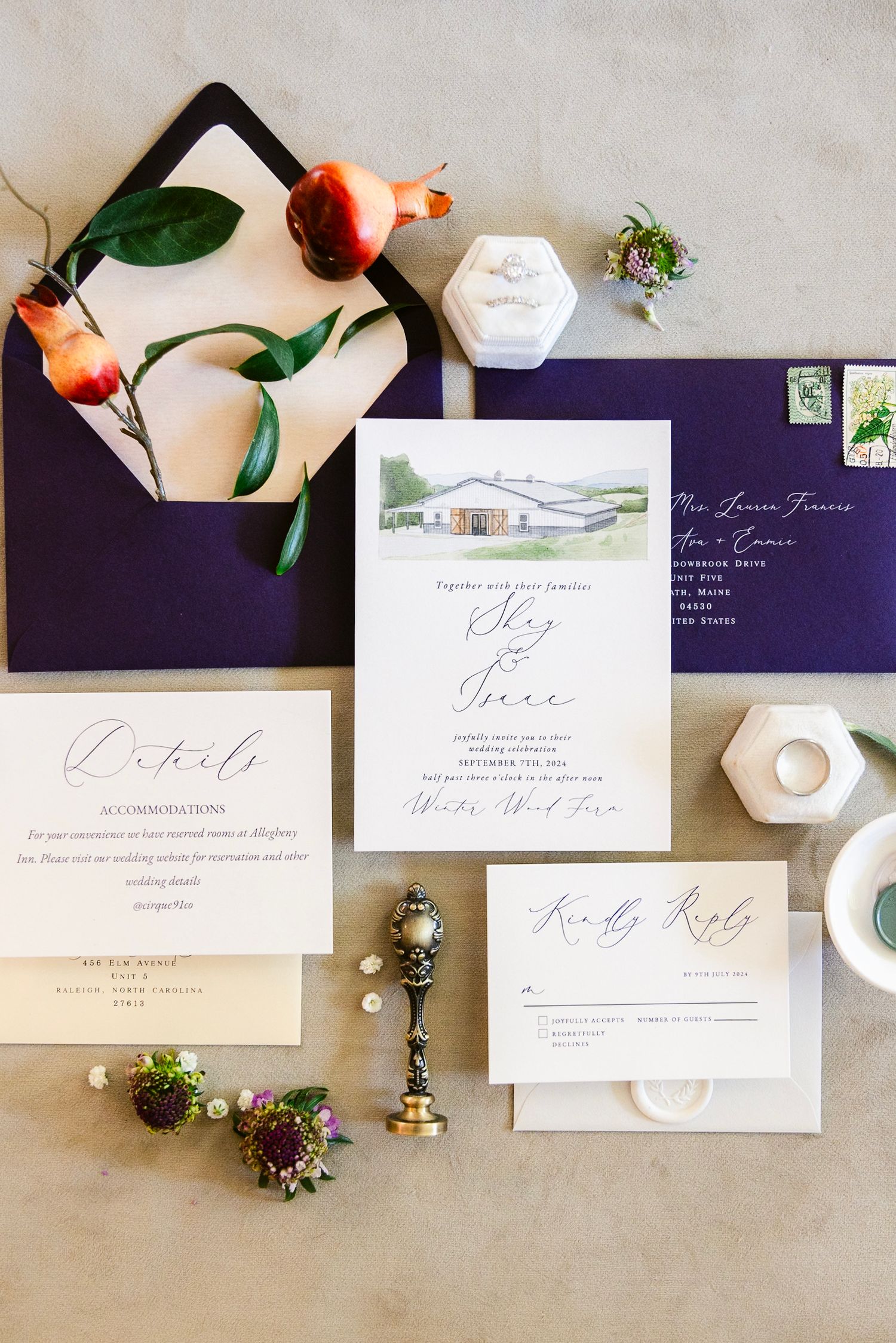 Elegant wedding invitation suite with calligraphy on white paper and navy blue envelopes styled with peaches and florals.