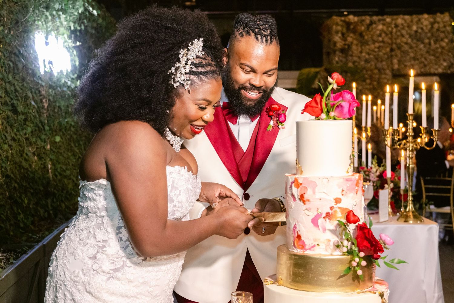 Wedding cake cutting celebration with warm lighting and festive atmosphere.