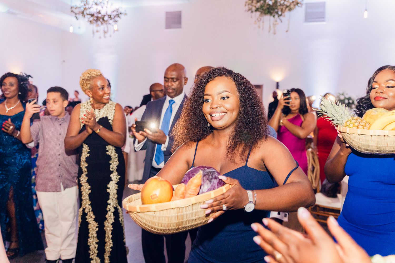 Wedding guests dancing and celebrating during a lively indoor reception party.
