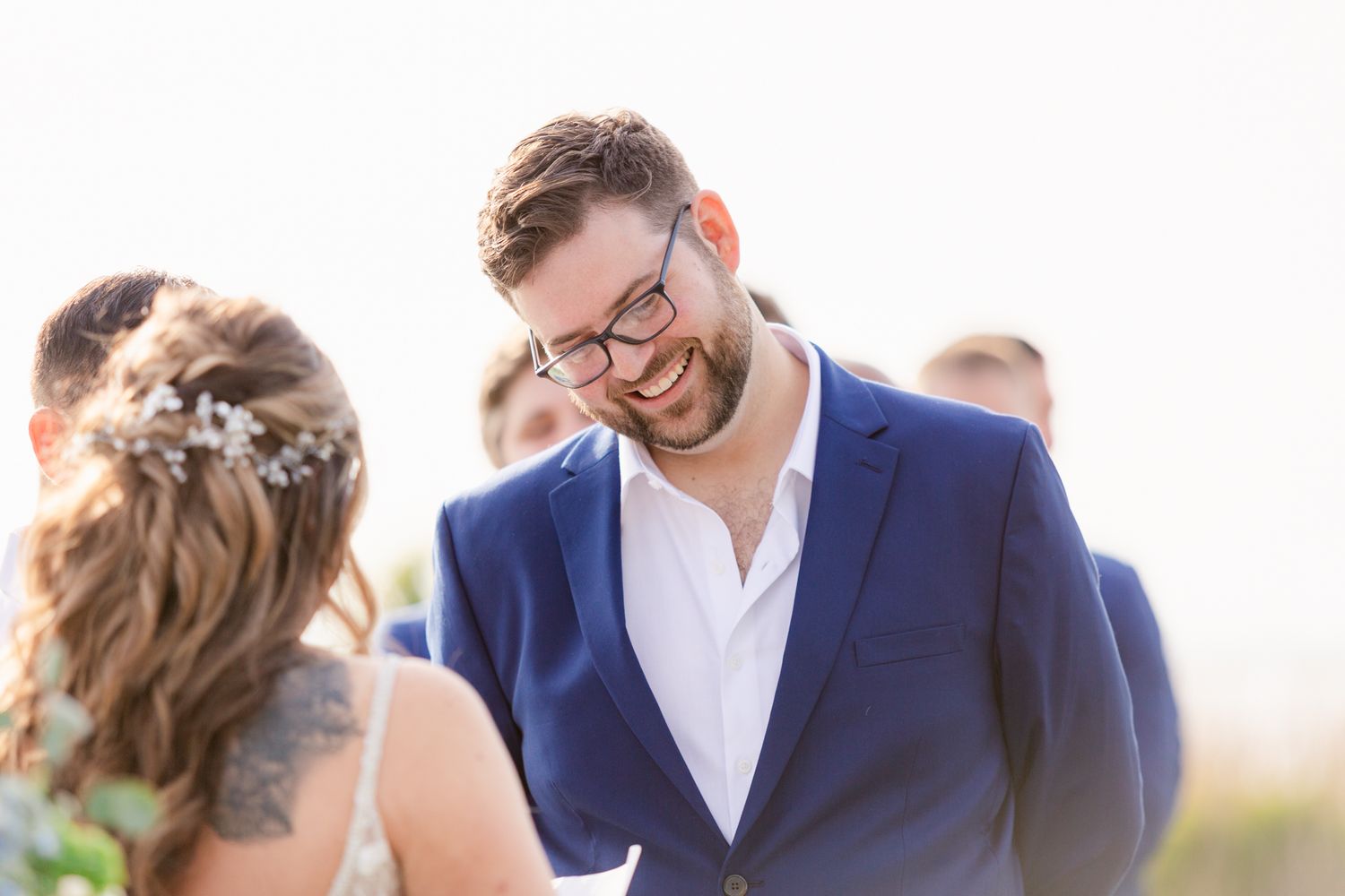 A bride and groom share a joyful moment together during their outdoor wedding celebration at sunset.