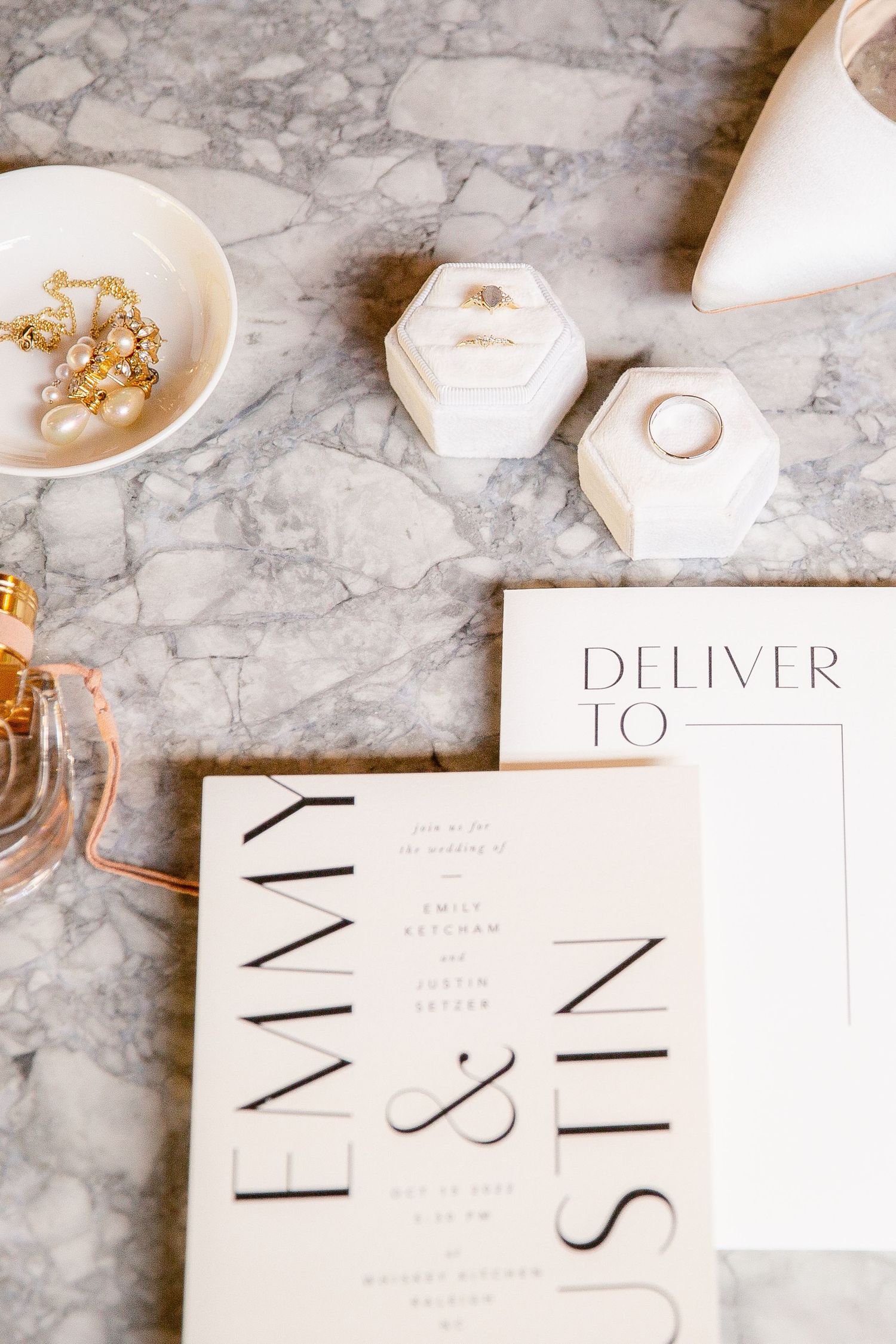 Minimalist white envelopes with black calligraphy text on a marble surface with gold accents.