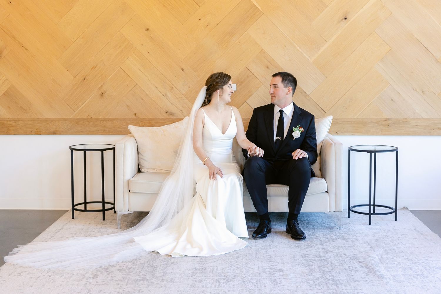 Minimalist modern wedding photo against a geometric wooden wall pattern.