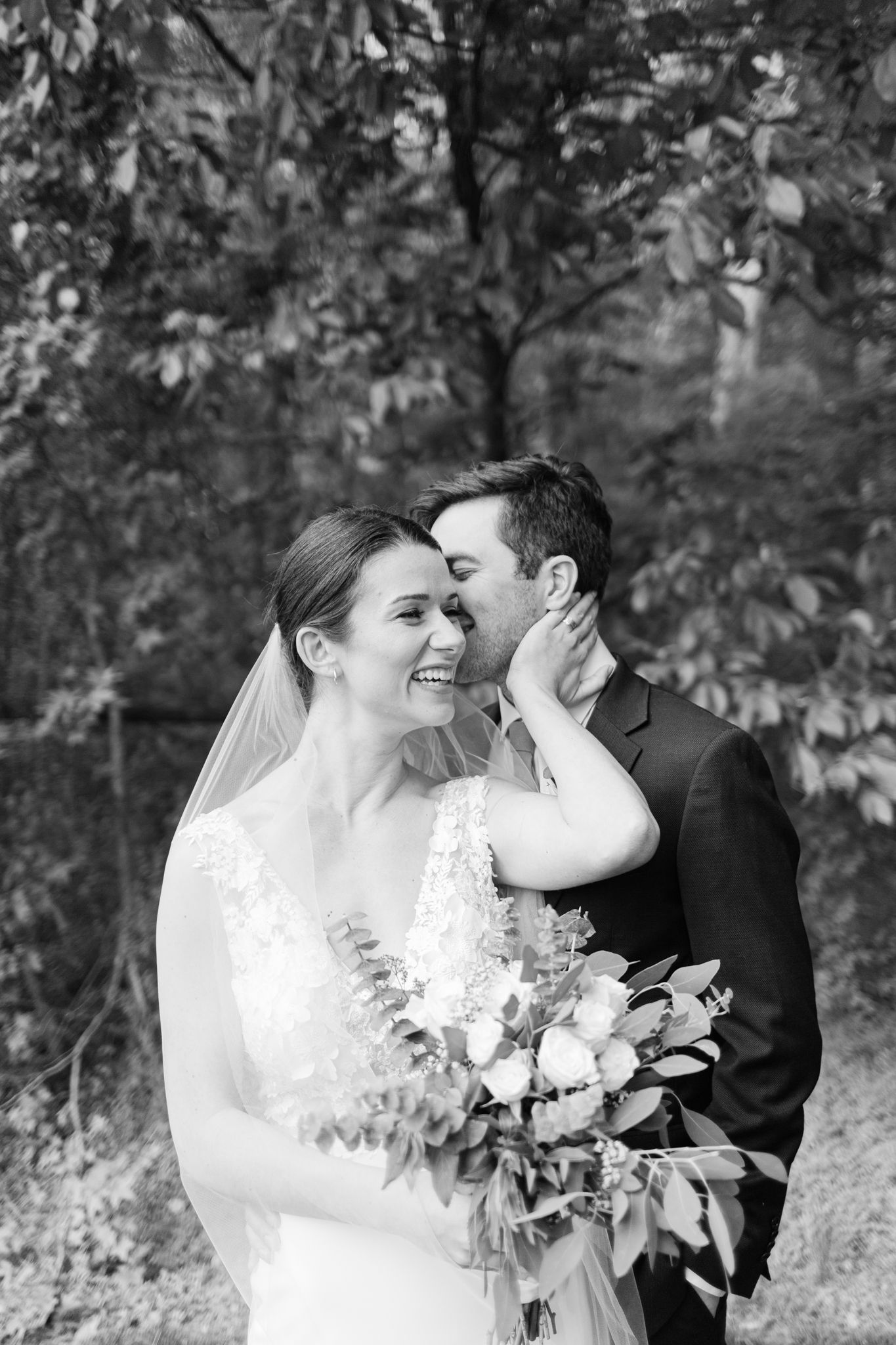 A romantic black and white wedding photo series showing tender moments between newlyweds in a natural outdoor setting.