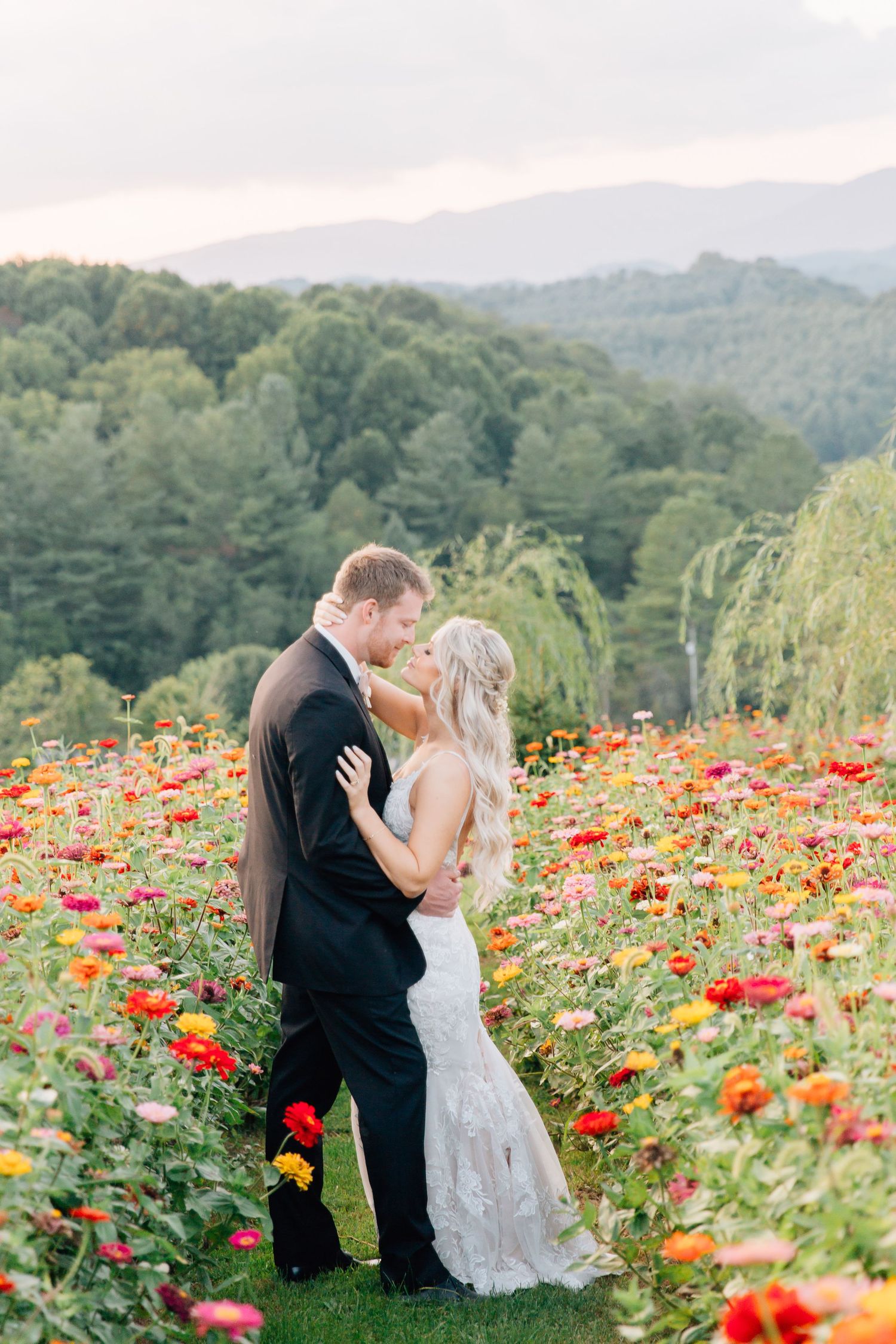 Romantic wedding portraits in a vibrant field of red and yellow poppies with mountain backdrop.