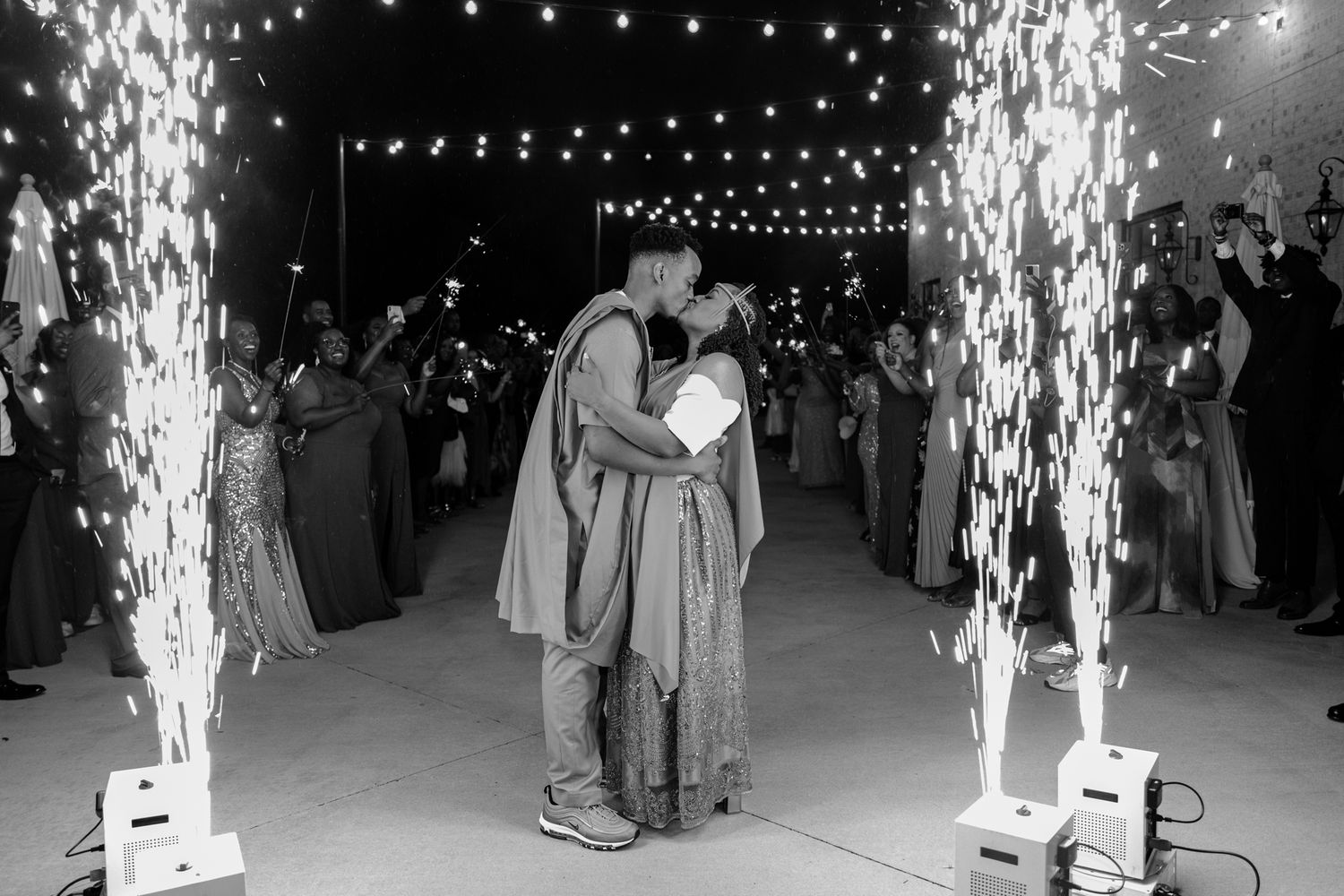 A series of black and white photographs showing sparklers and fireworks at a nighttime celebration or event.