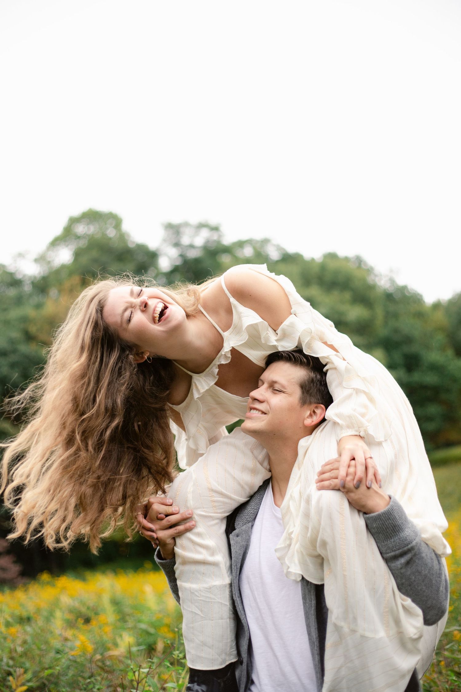 A playful couple moment captured in a wildflower field during golden hour.
