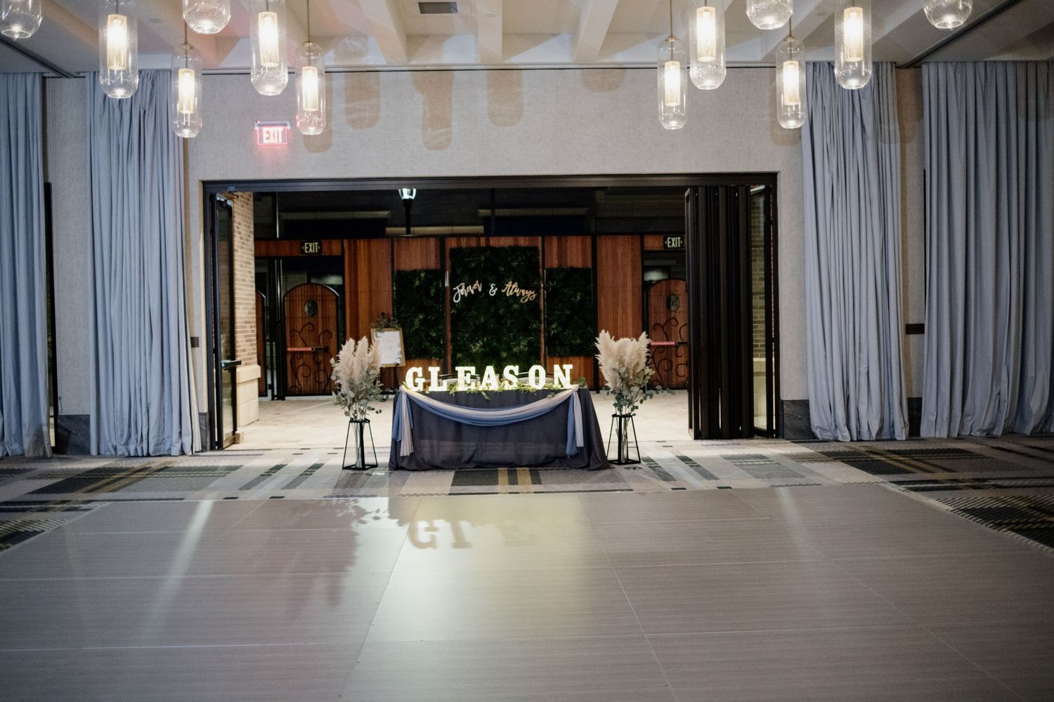 Wedding reception ballroom with dramatic lighting and navy accents featuring sweetheart table.