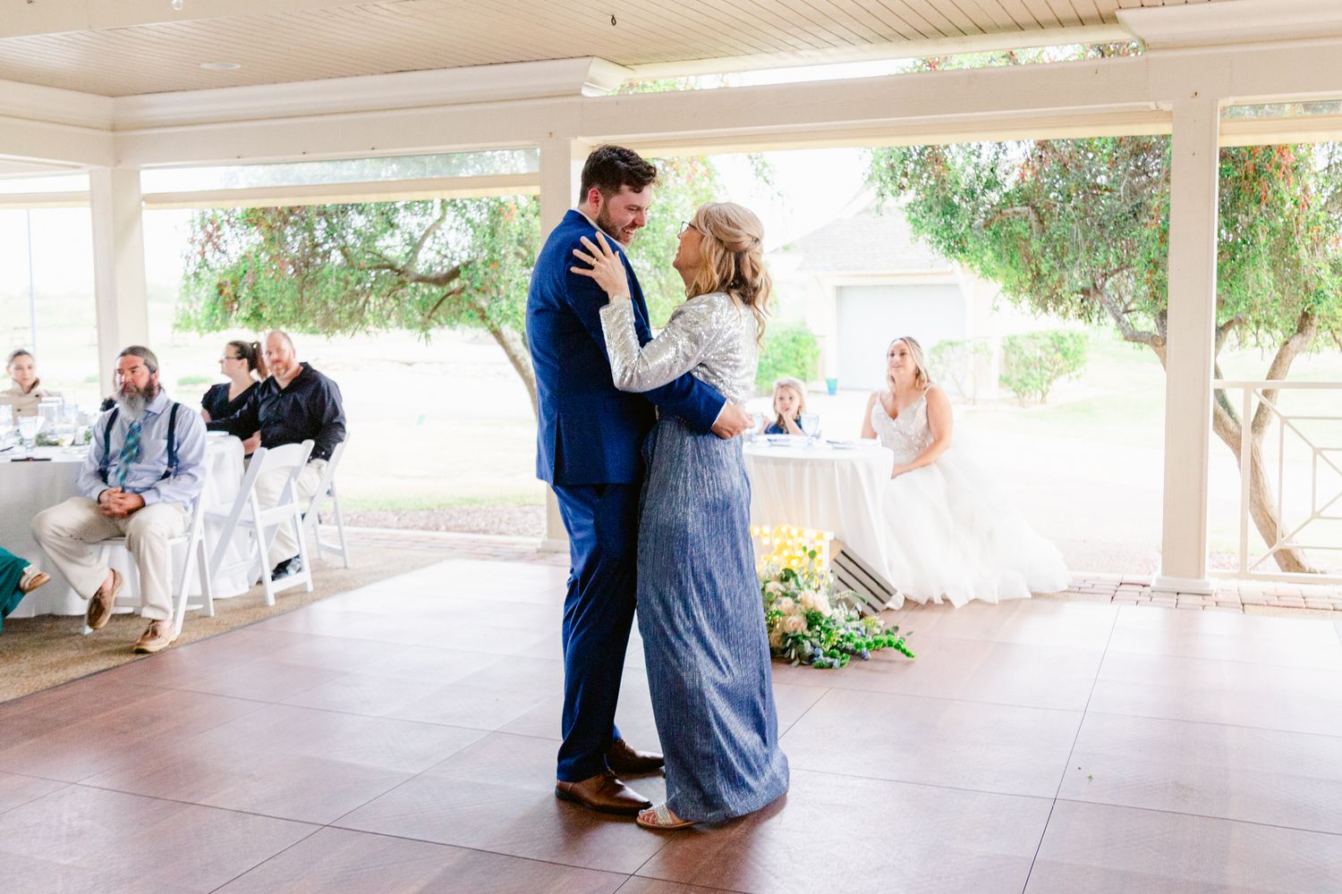 Wedding reception venue with couples dancing and celebrating on a covered outdoor patio.