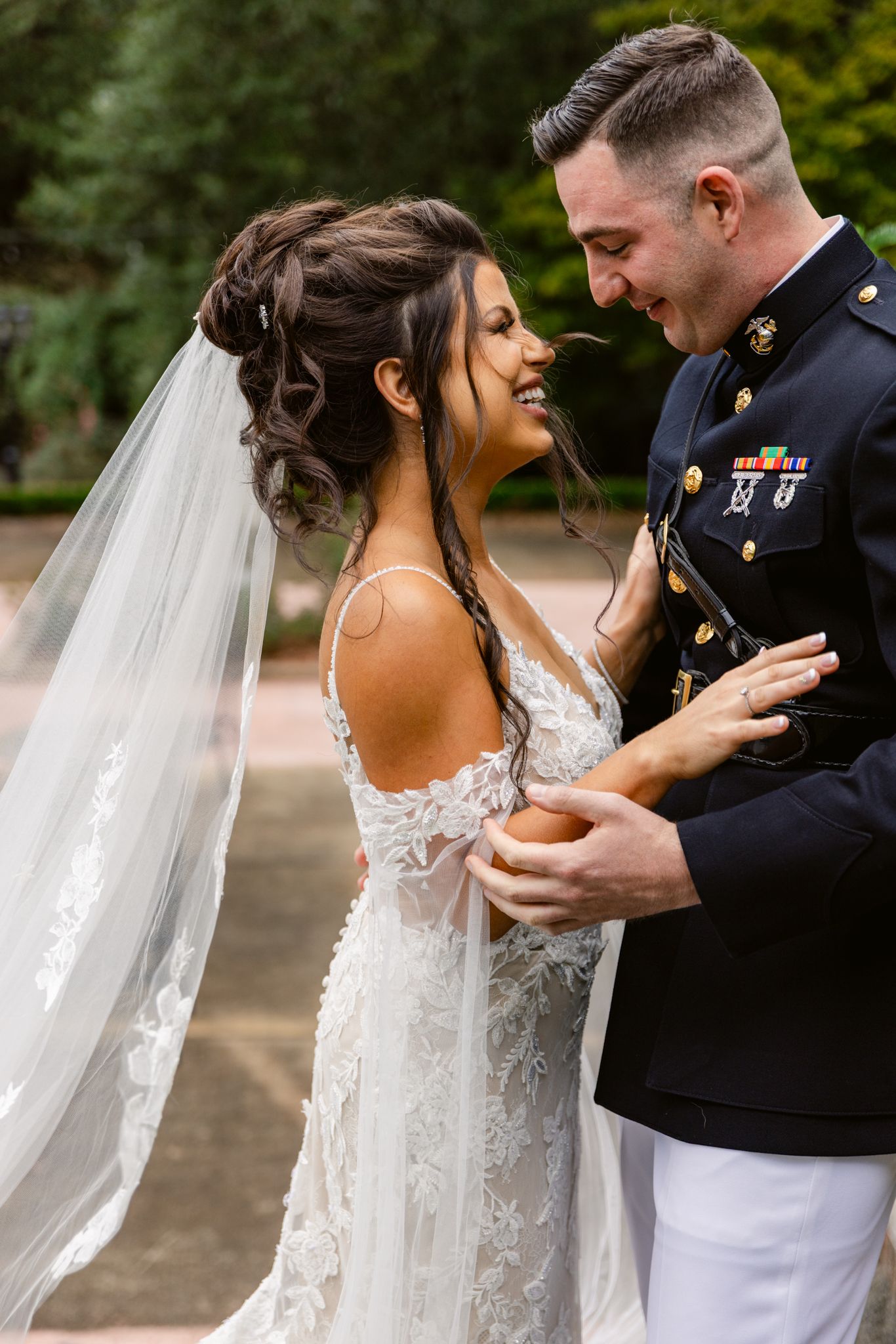A bride and groom share an intimate moment during their wedding photo session in a lush outdoor setting.