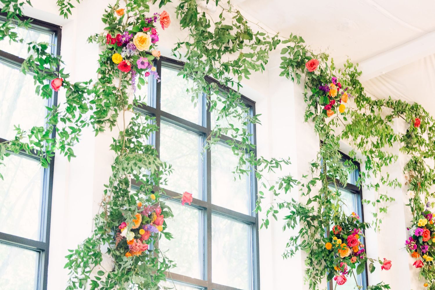 Wedding venue windows adorned with cascading floral arrangements and greenery.