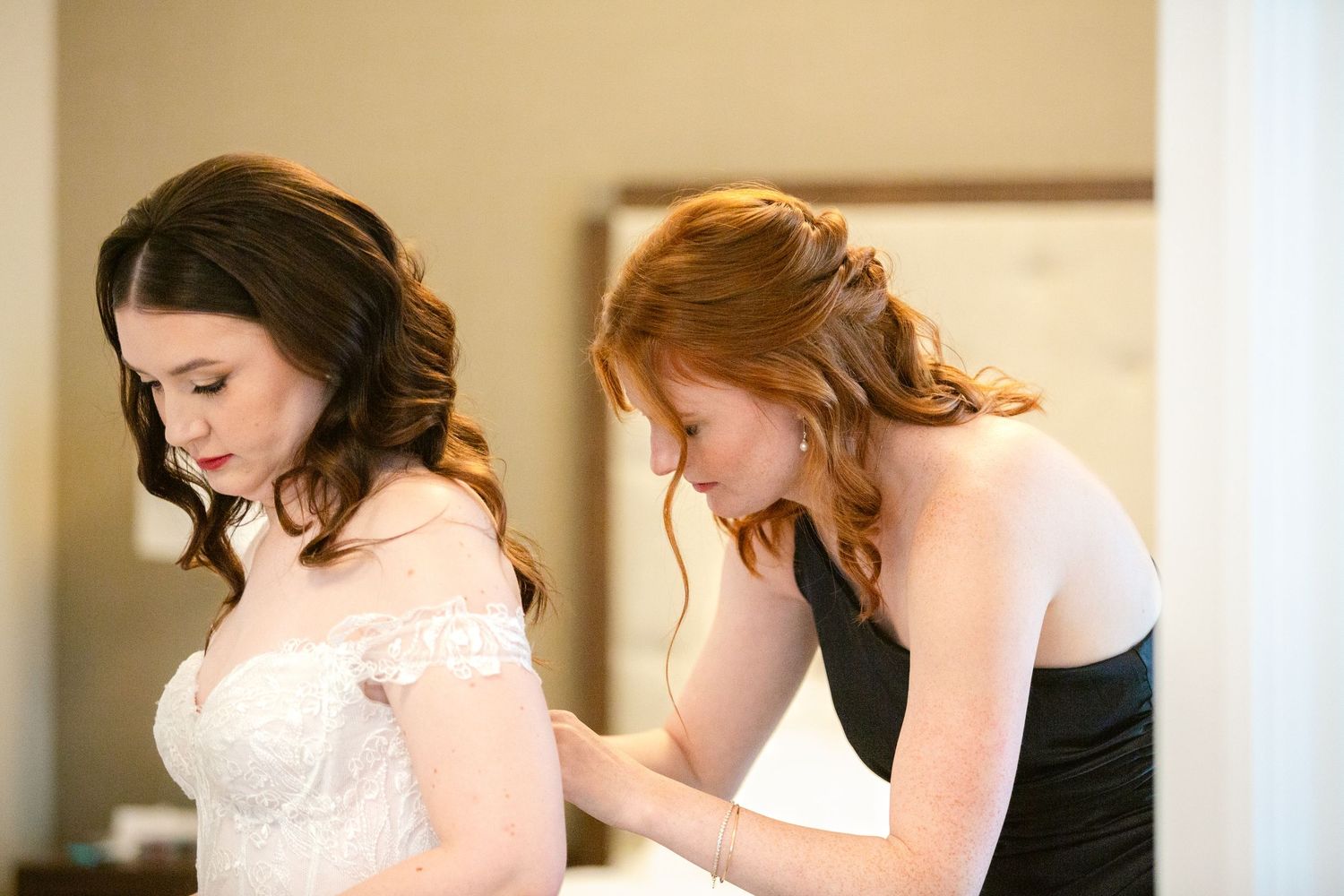 People in formal attire gathered indoors during a wedding preparation event.